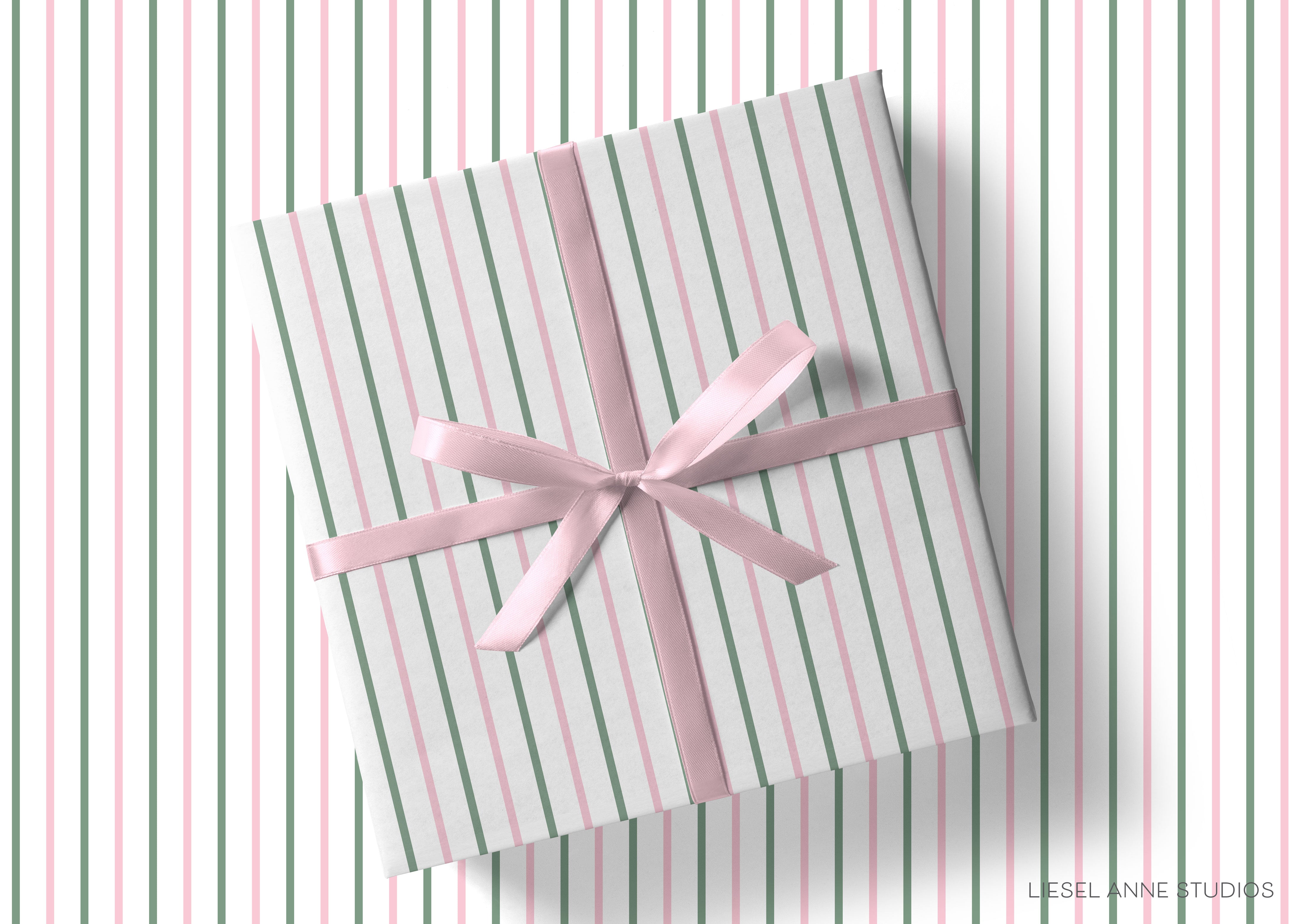 A gift box with a pink ribbon tied around it, placed on a striped background.