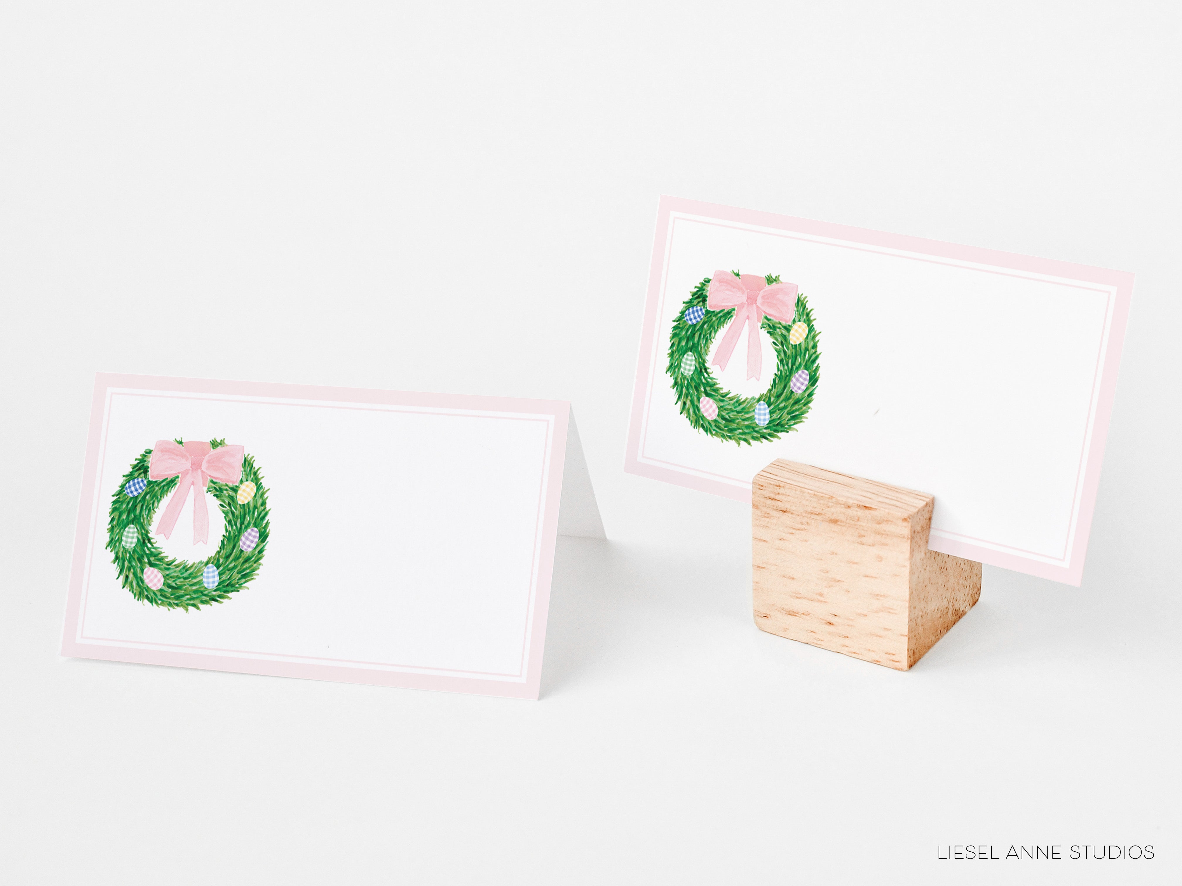 two place cards with a wreath design on them, placed on a white background.