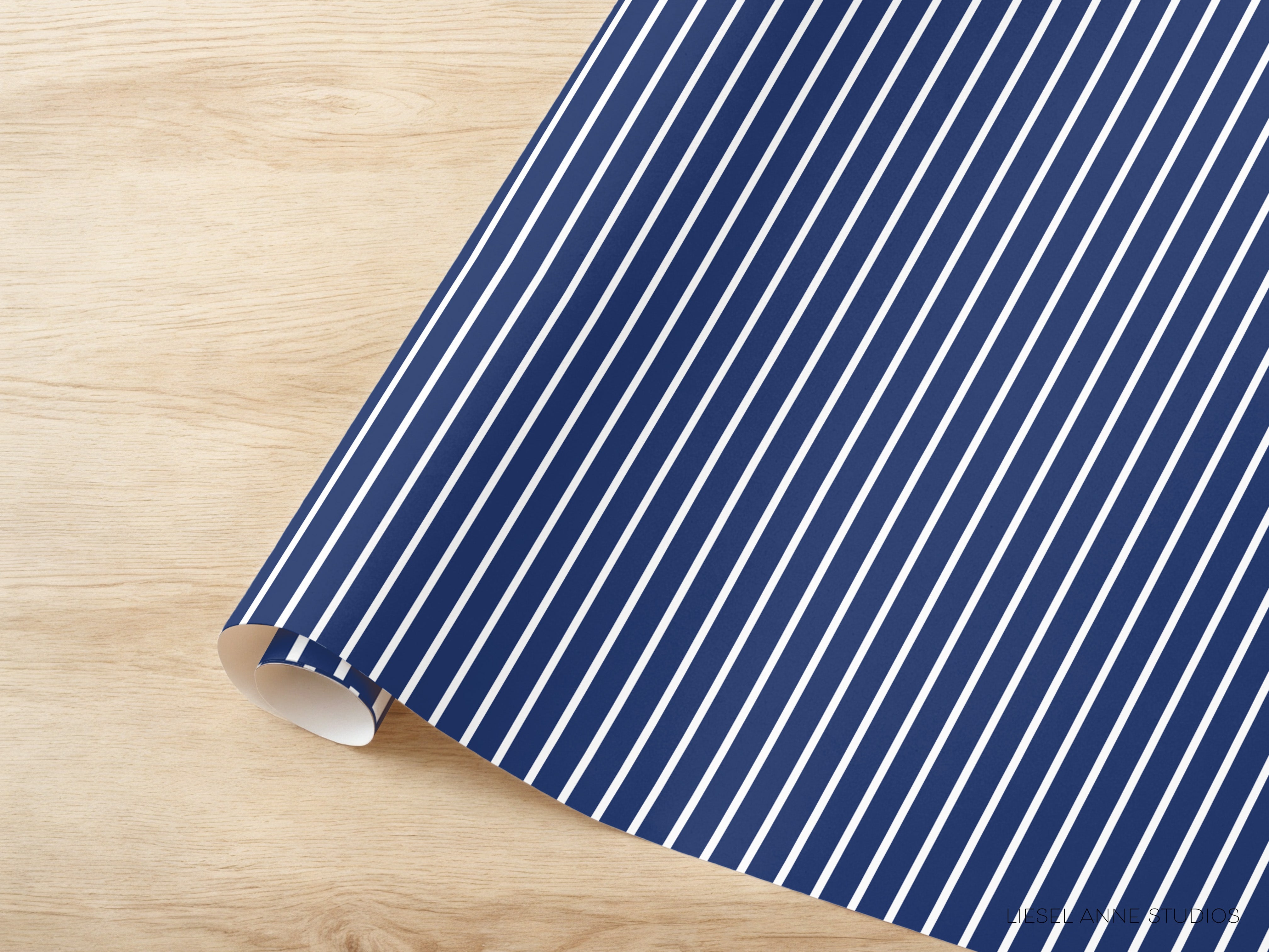 A roll of blue and white striped paper is placed on a wooden surface.