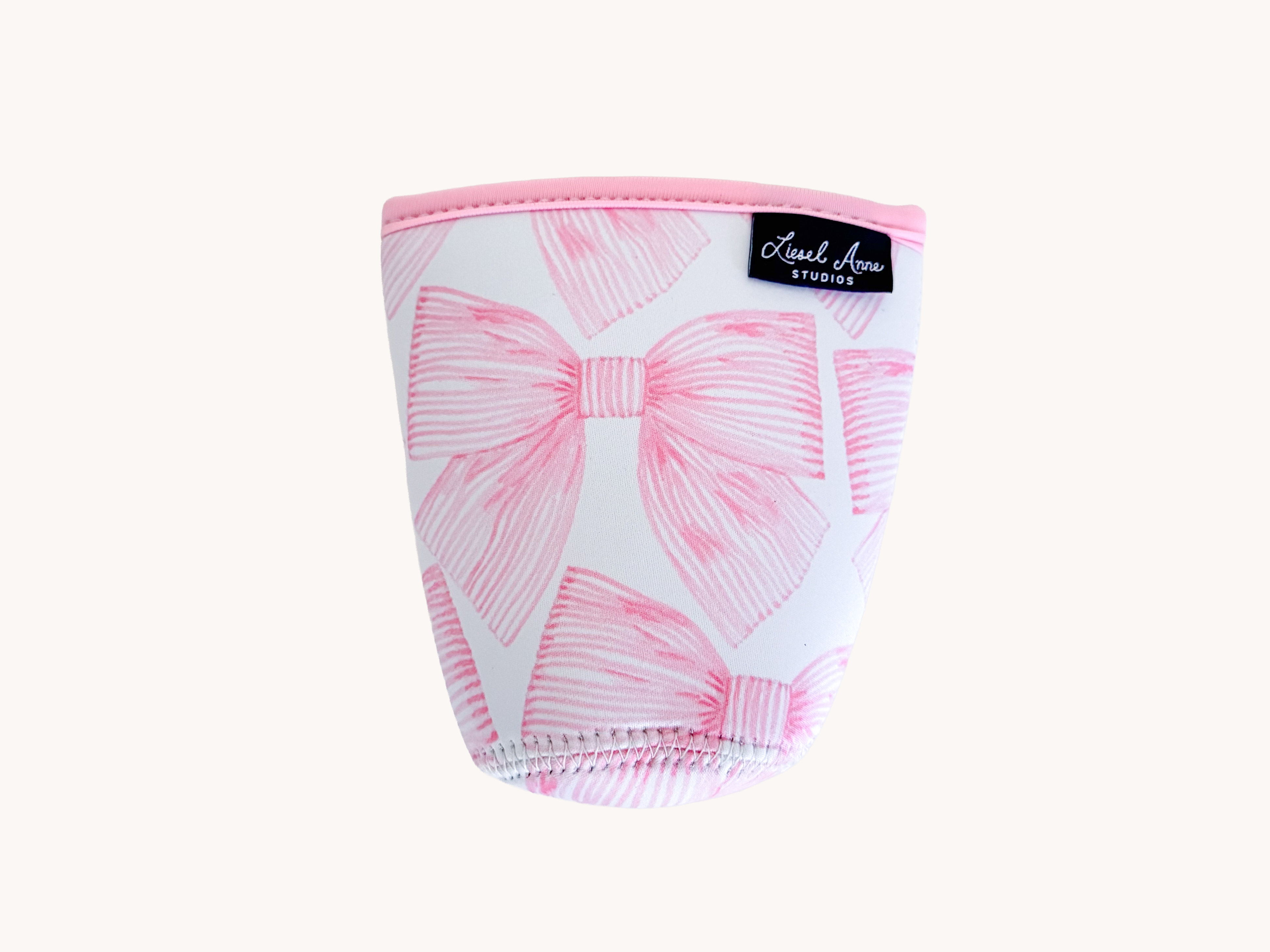 A pink and white patterned cup or container with a bow design.