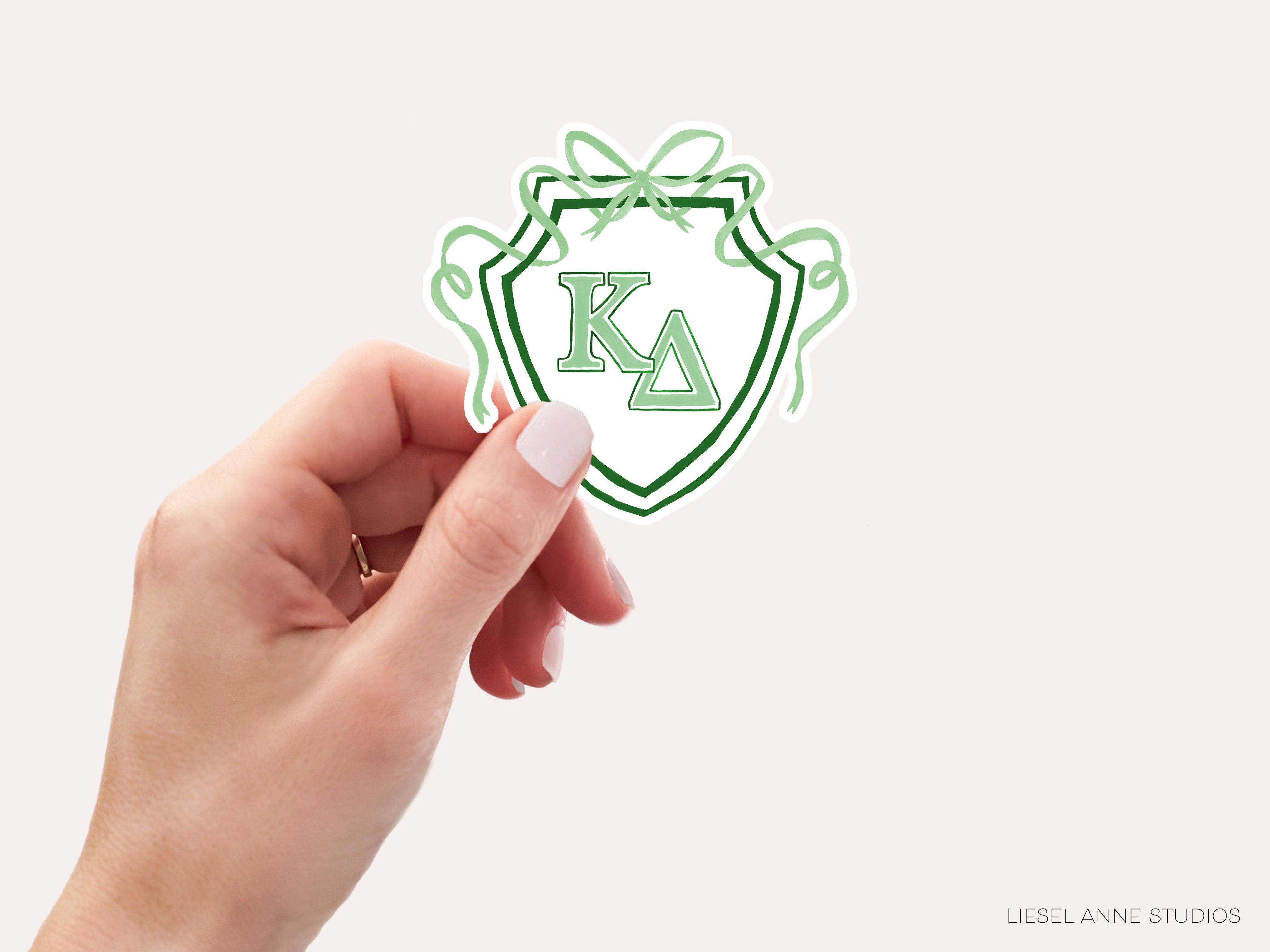 a hand holding a sticker with the letter k on it