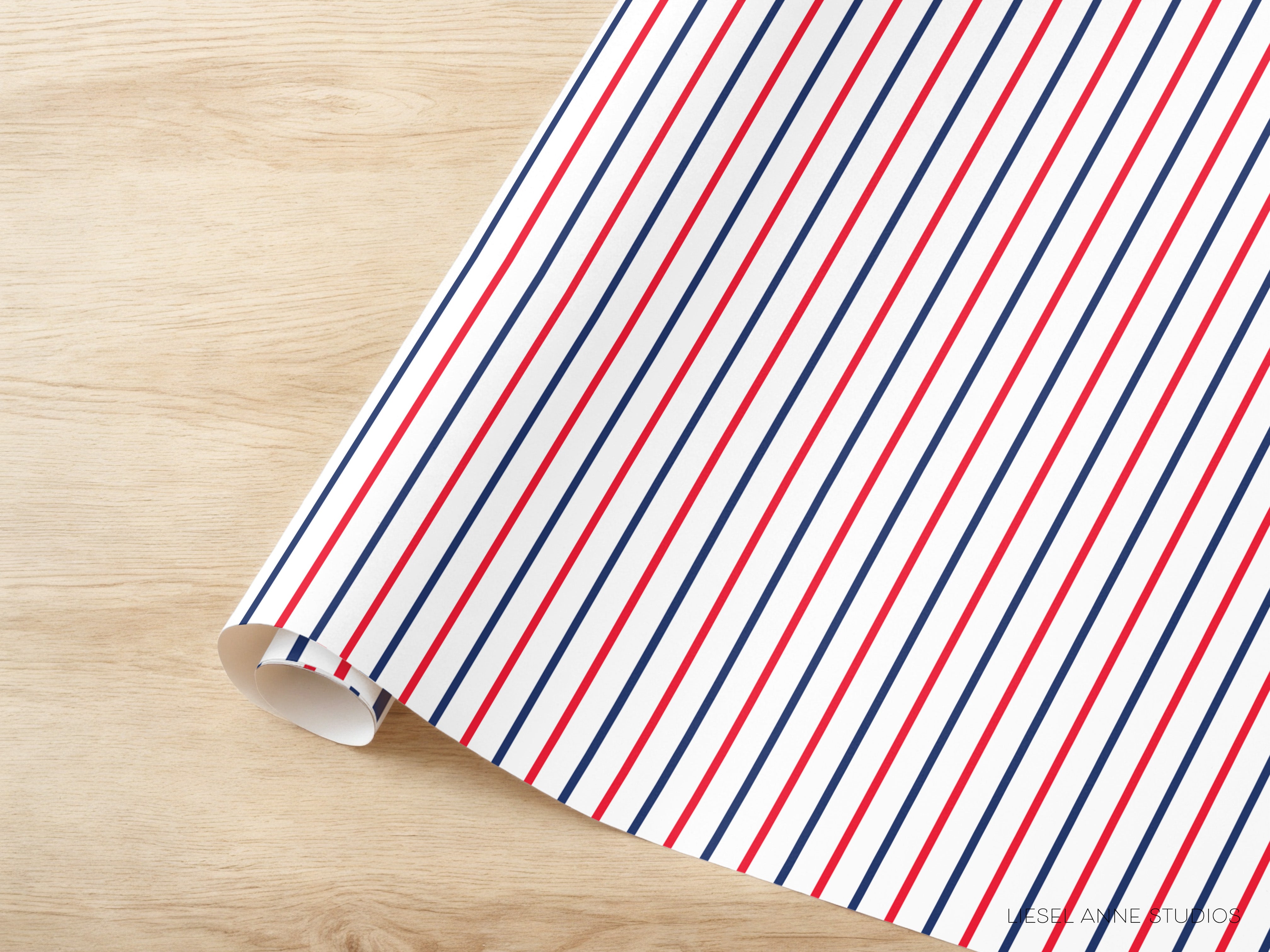 A roll of paper with a striped pattern in red, white, and blue colors is placed on a wooden surface.