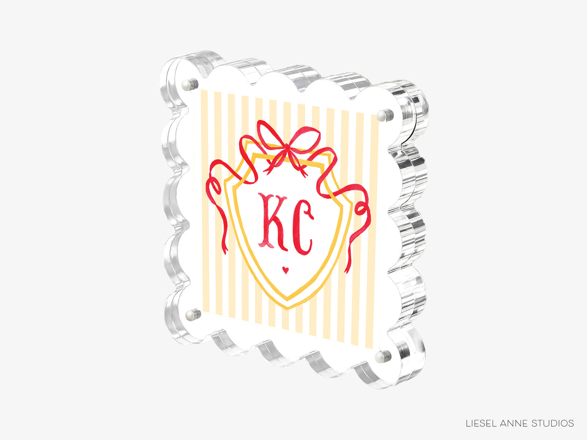 A 3D rendering of a shield-shaped object with a red ribbon and the letters "KC" prominently displayed in the center.