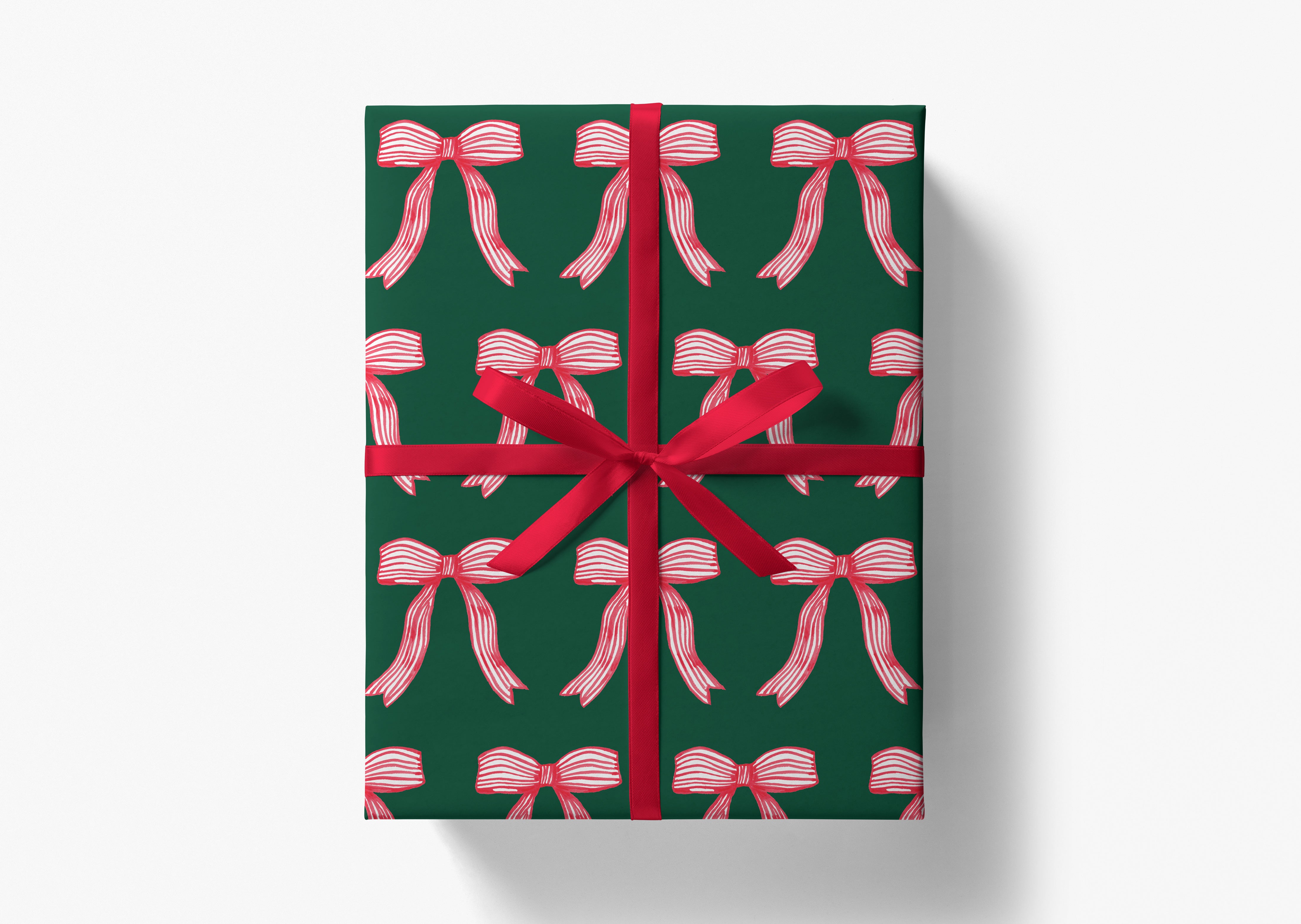 A green gift box with a red ribbon and a repeating pattern of red bows on the wrapping paper.
