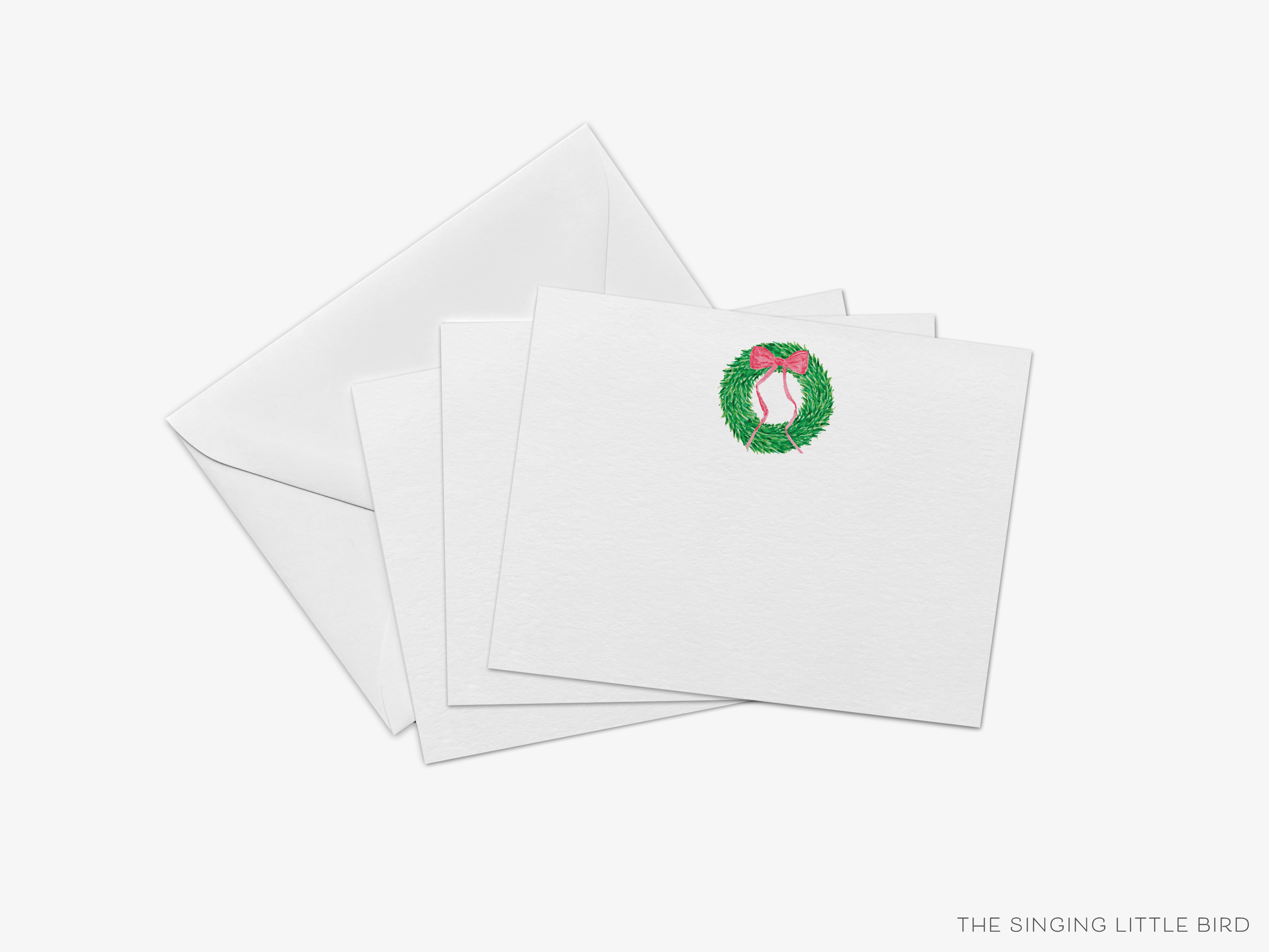 a set of white greeting cards with a wreath design on the top card.
