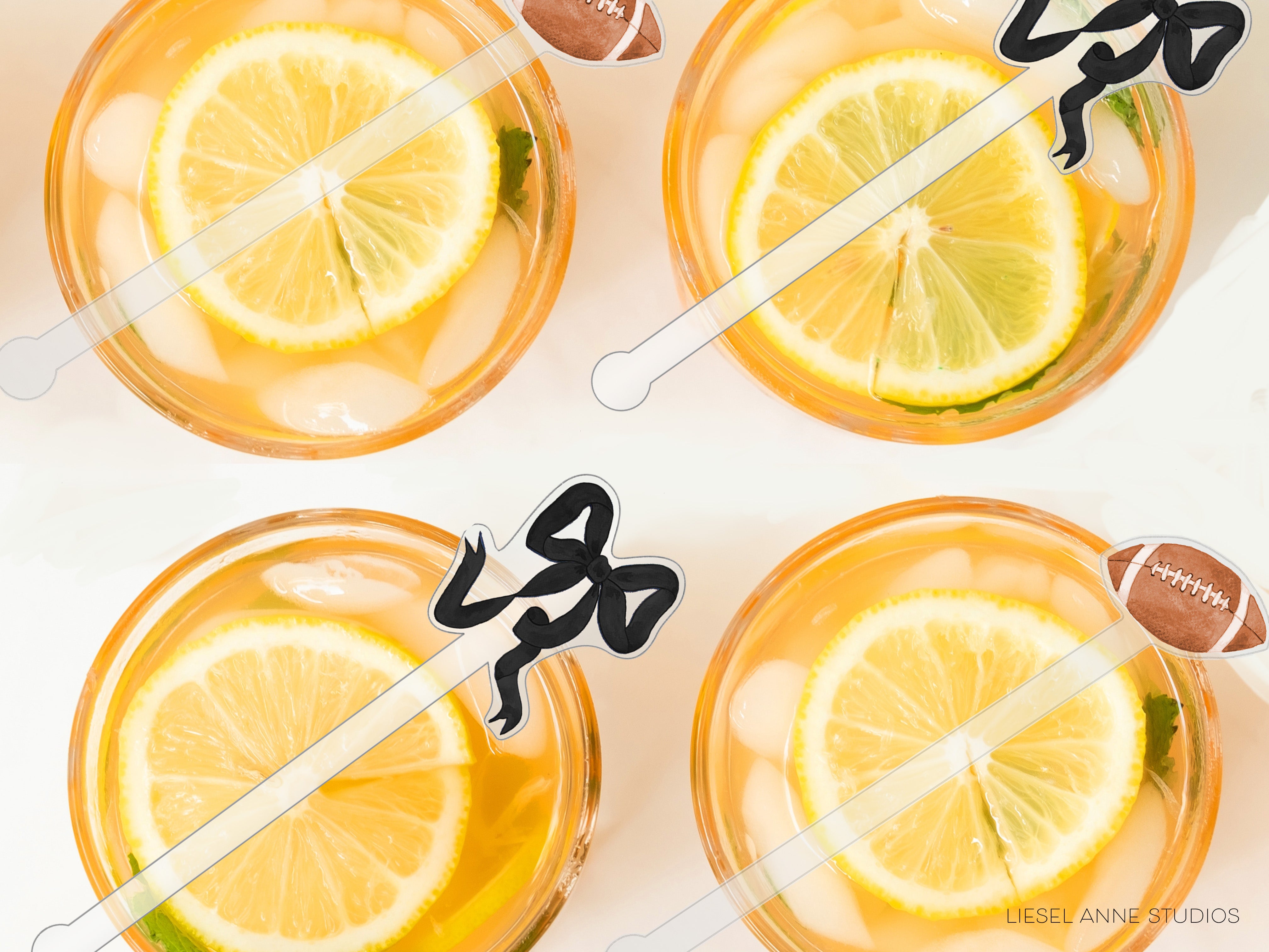four glasses filled with a yellow liquid, each containing a slice of lemon. The glasses are accompanied by football-themed straws, suggesting a festive or sports-related occasion.