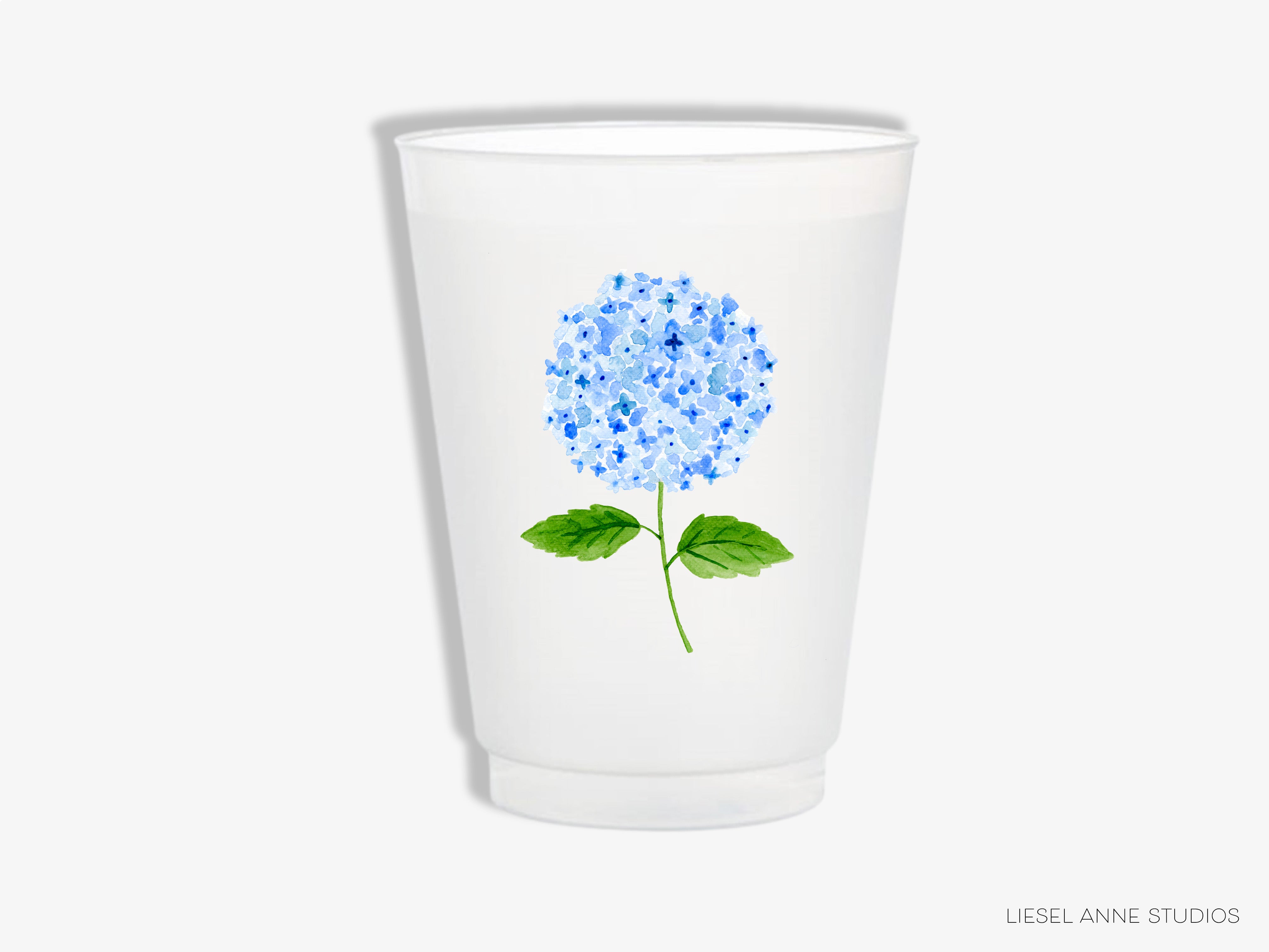 a shot glass with a blue flower on it