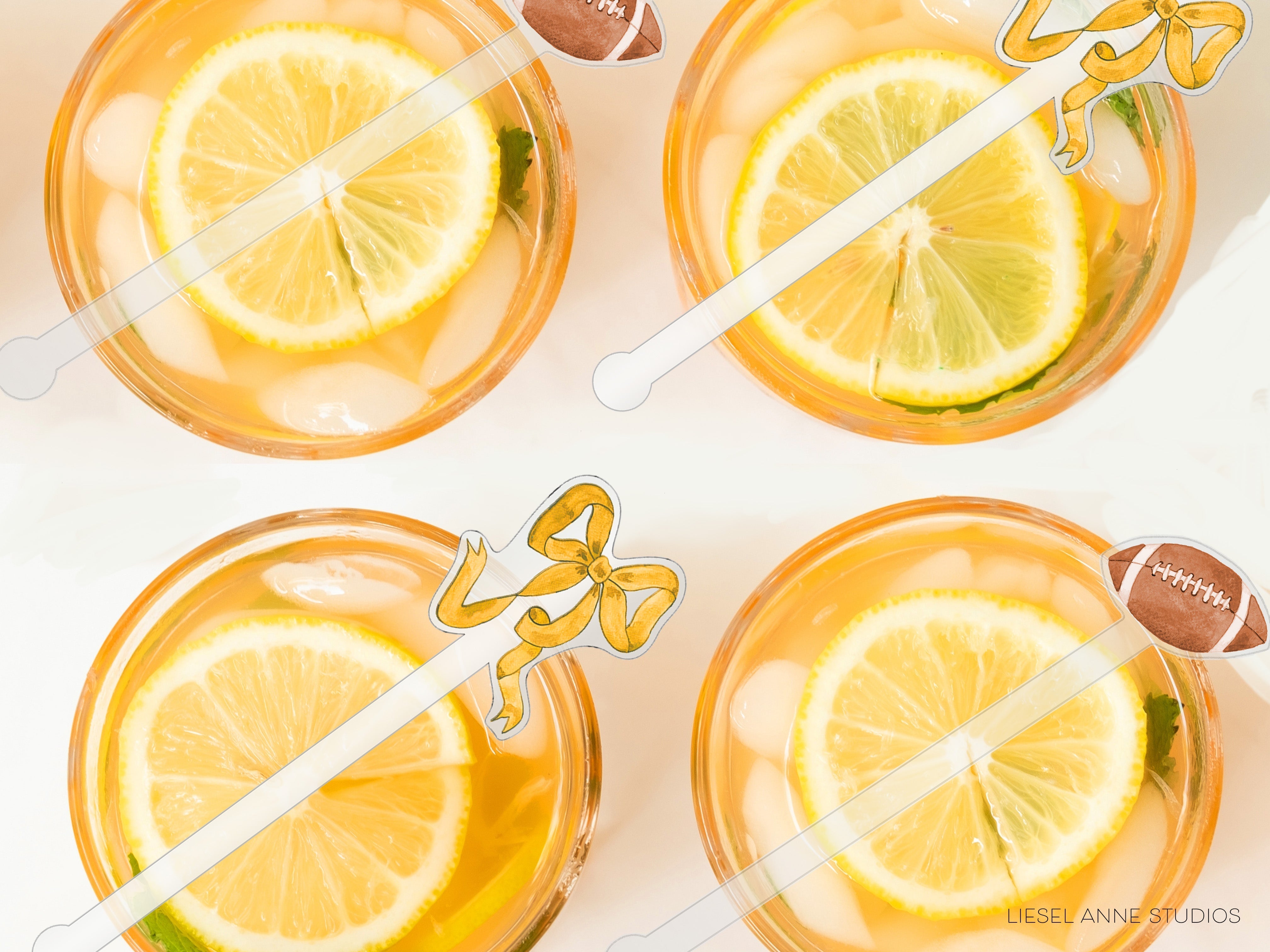 four glasses filled with a yellow liquid, each containing a slice of lemon and a football-shaped straw.