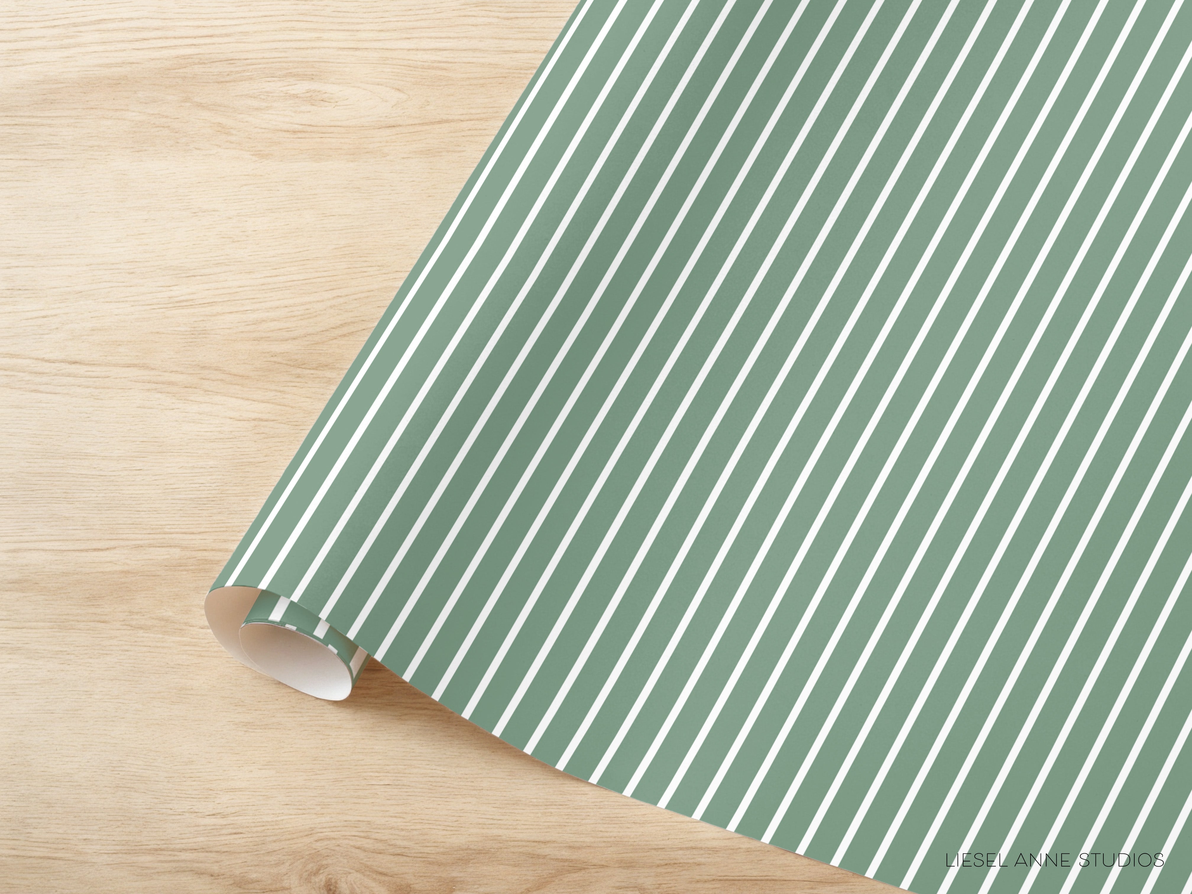 A roll of green and white striped paper is placed on a wooden surface.