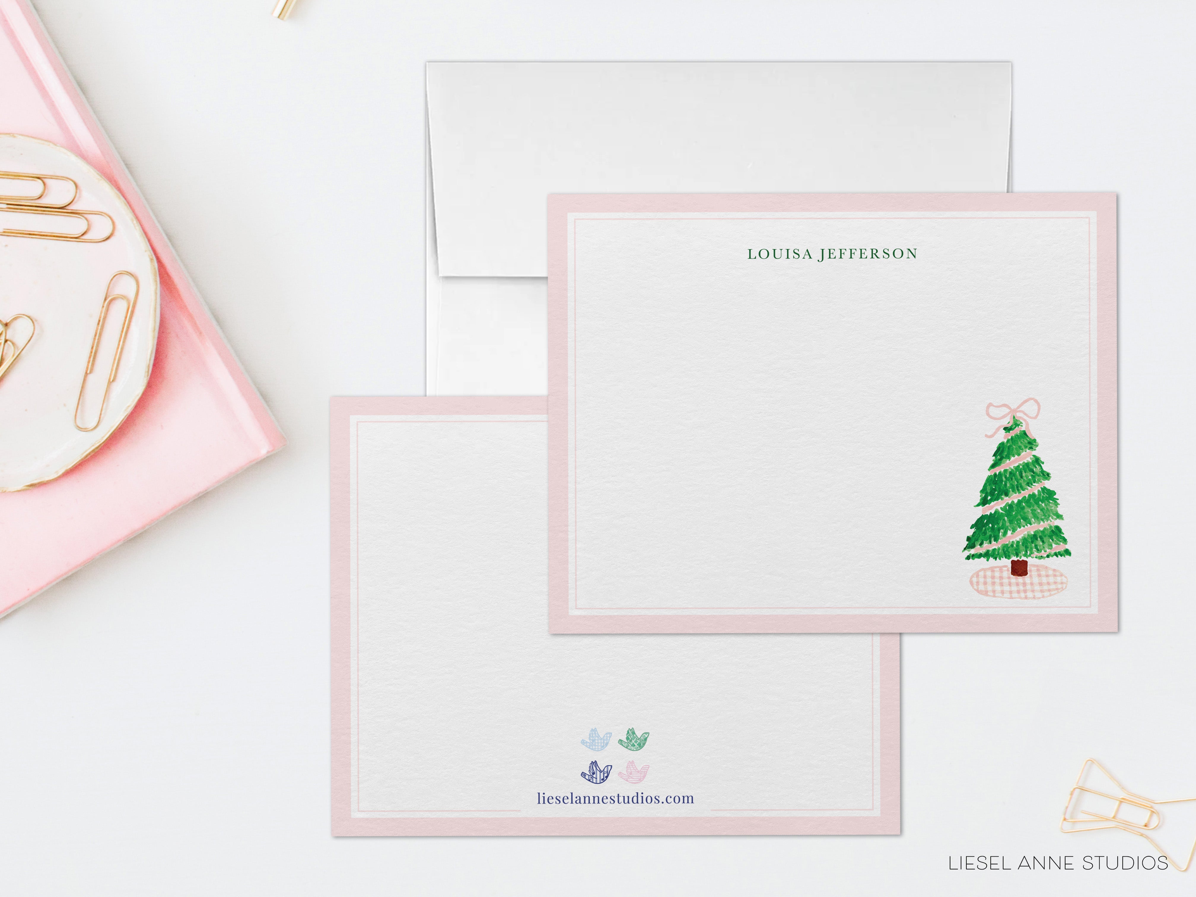 a pink envelope with a white card inside, both placed on a white surface.
