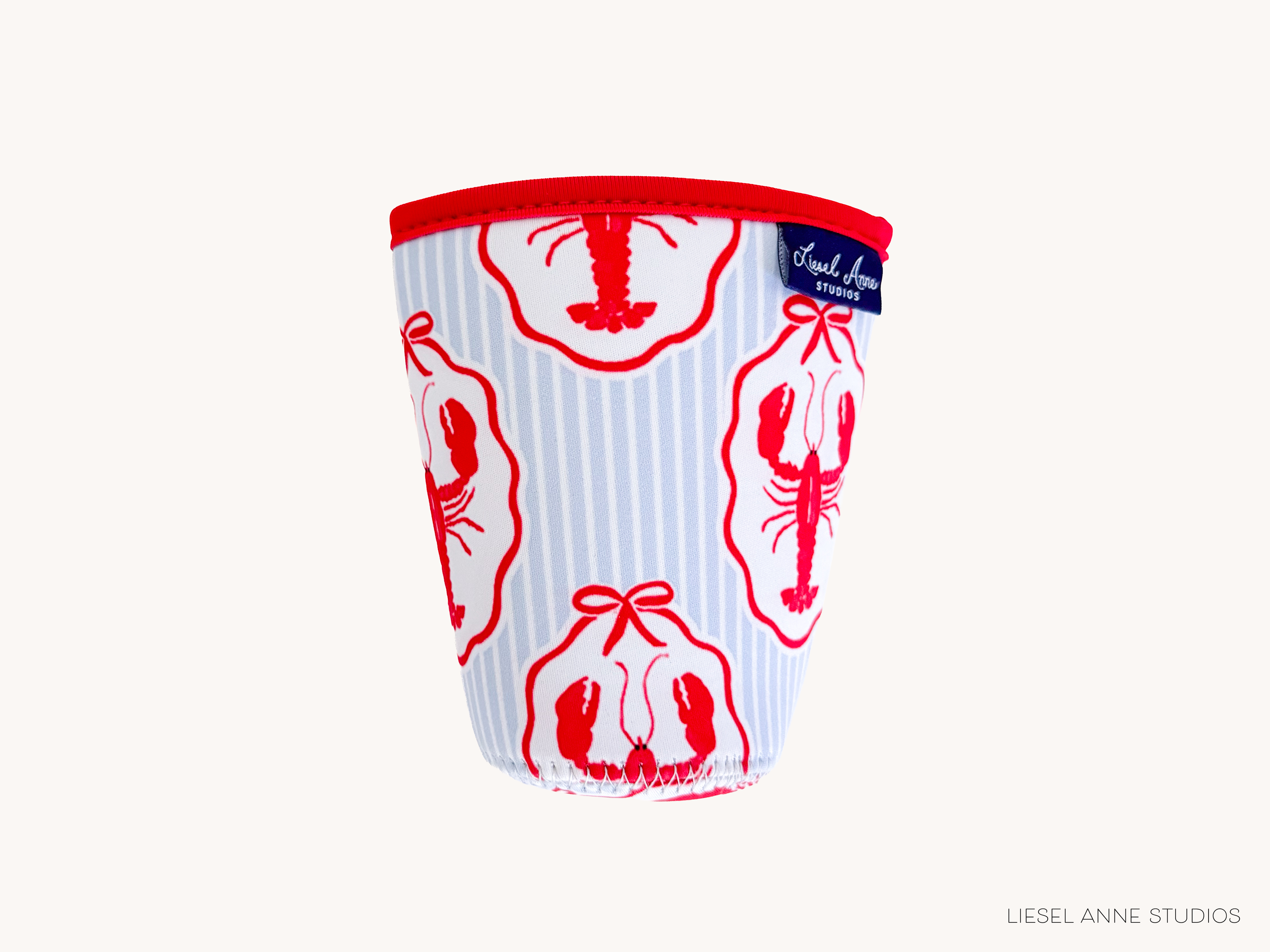 A cup with a red lobster design printed on it, featuring a red ribbon around the base.