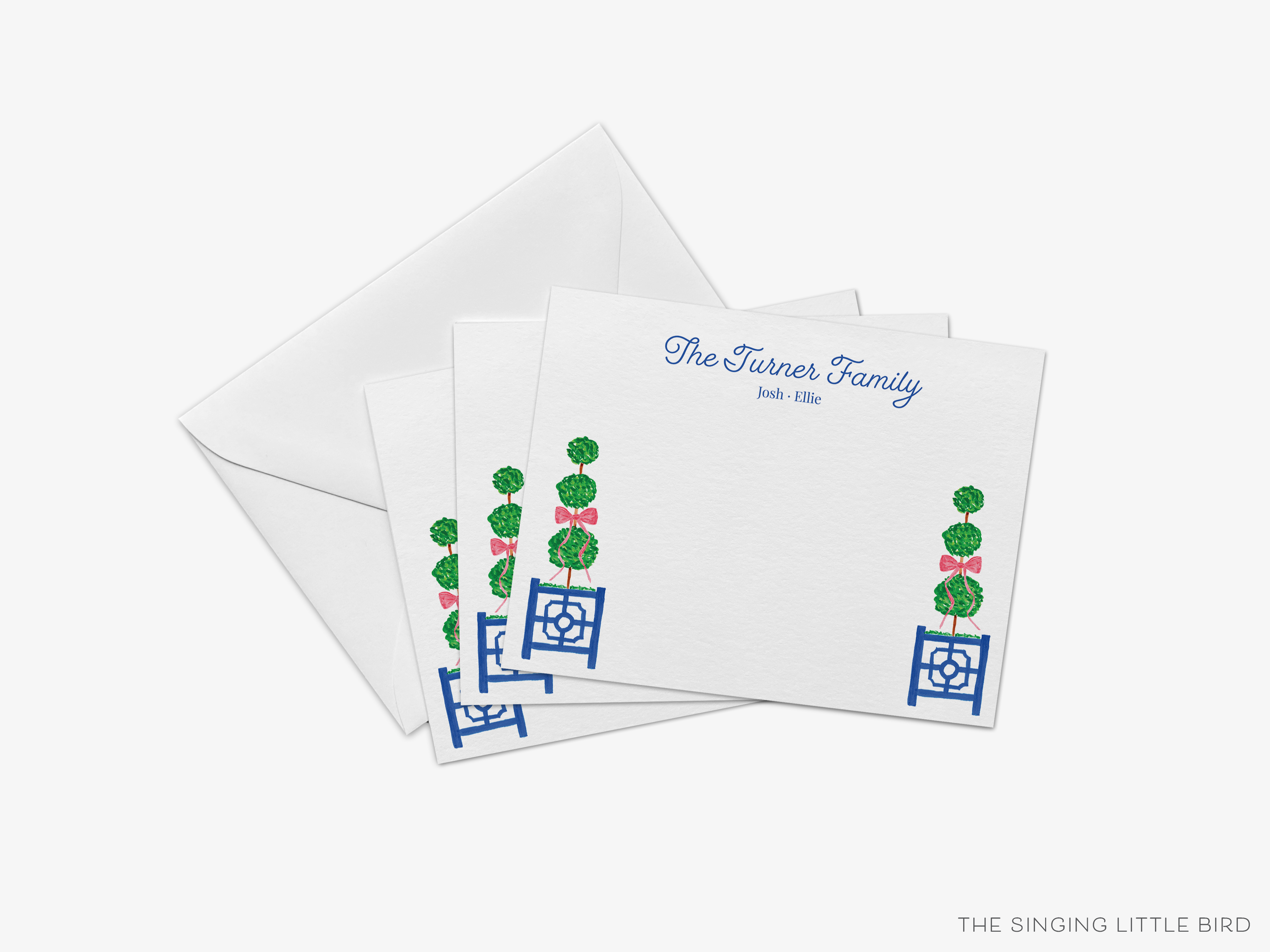a set of four white envelopes with blue and green designs, including a plant motif, and a note card with a family name and a floral design.