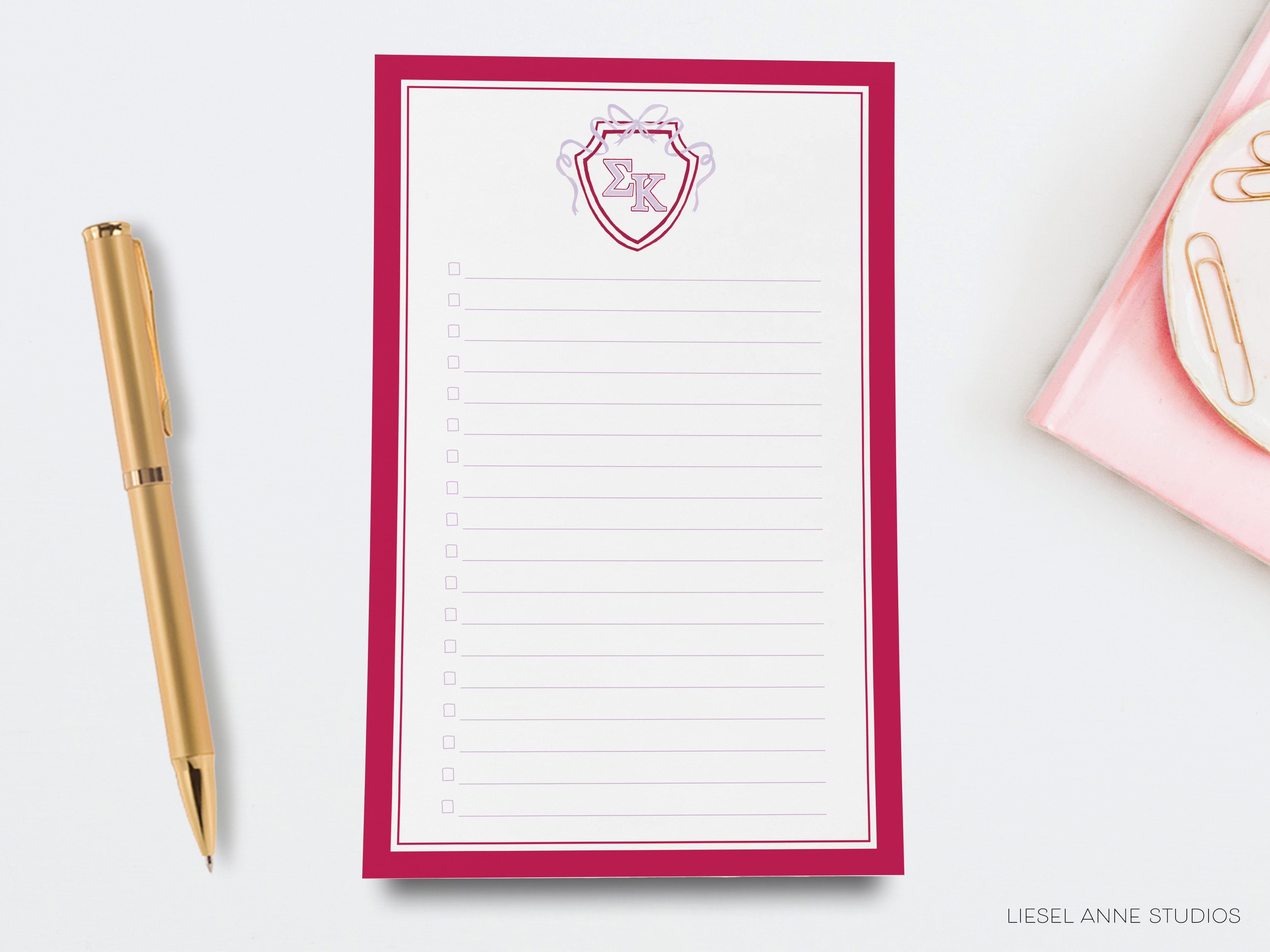 a notepad with a pen next to it on a desk