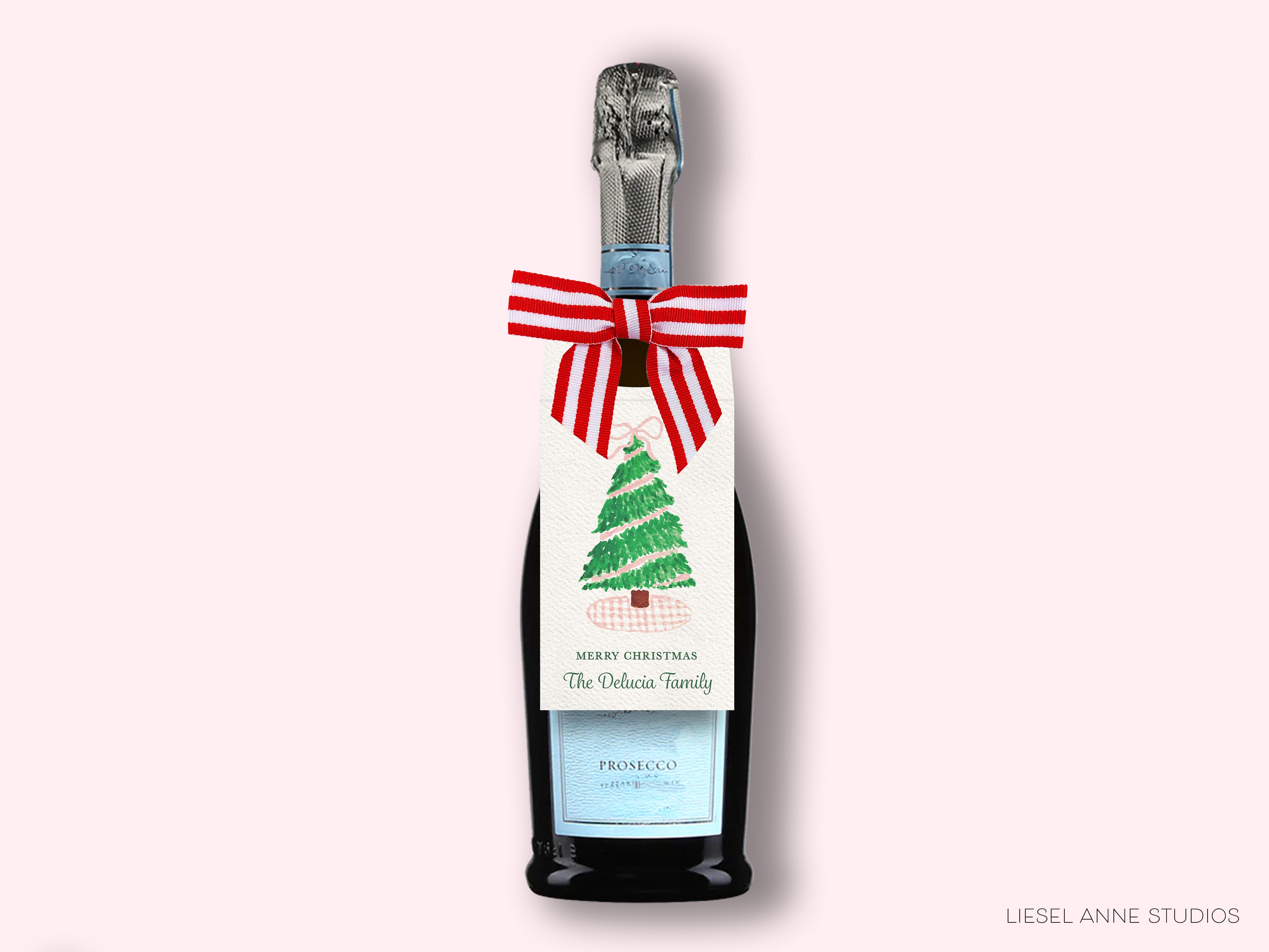 A bottle of Prosecco with a Christmas tree label, featuring a red and white striped ribbon and the text "Merry Christmas The Delia Family"