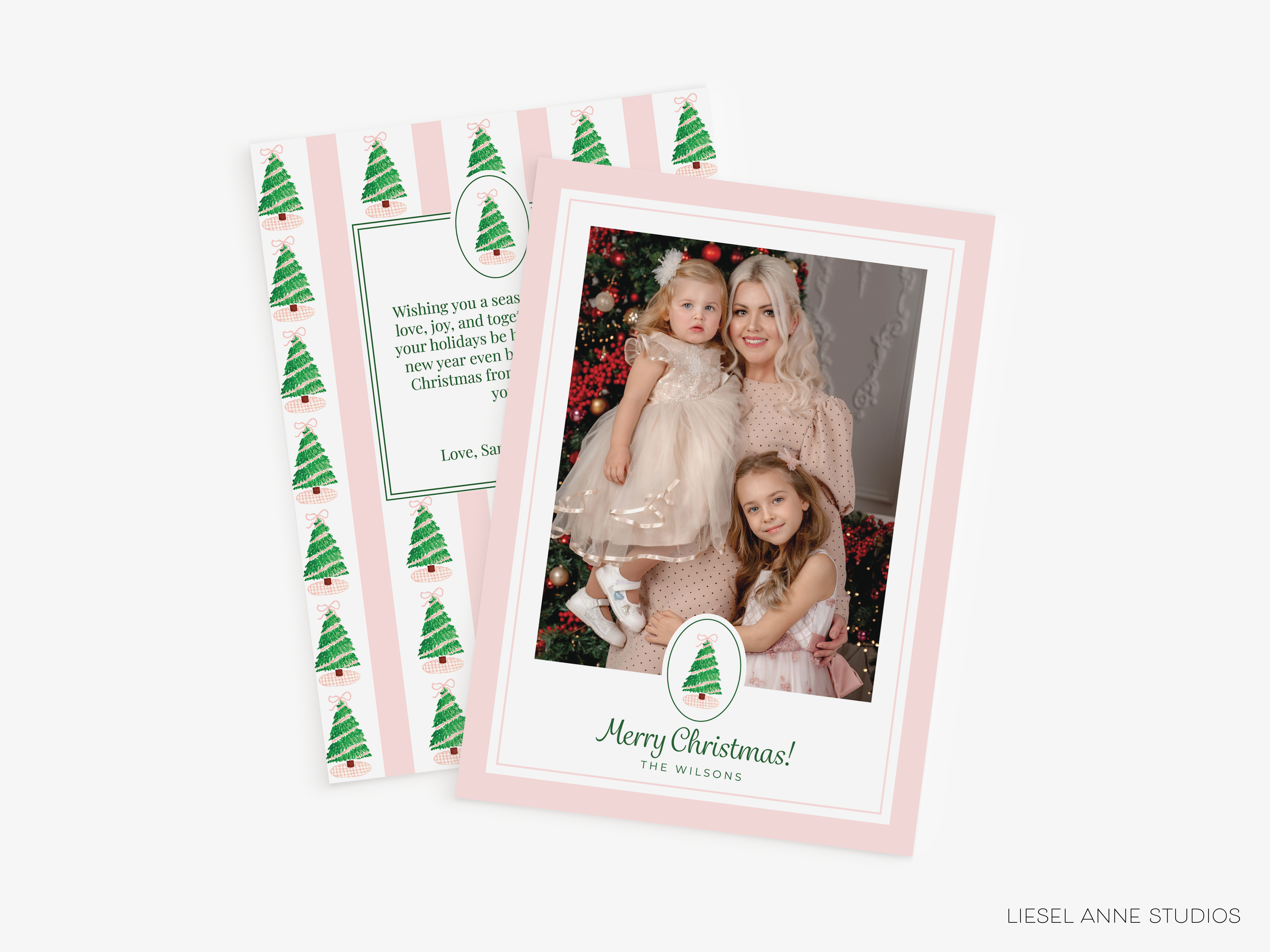 A pink Christmas card featuring a photo of three young girls, likely a family, with a festive holiday theme.