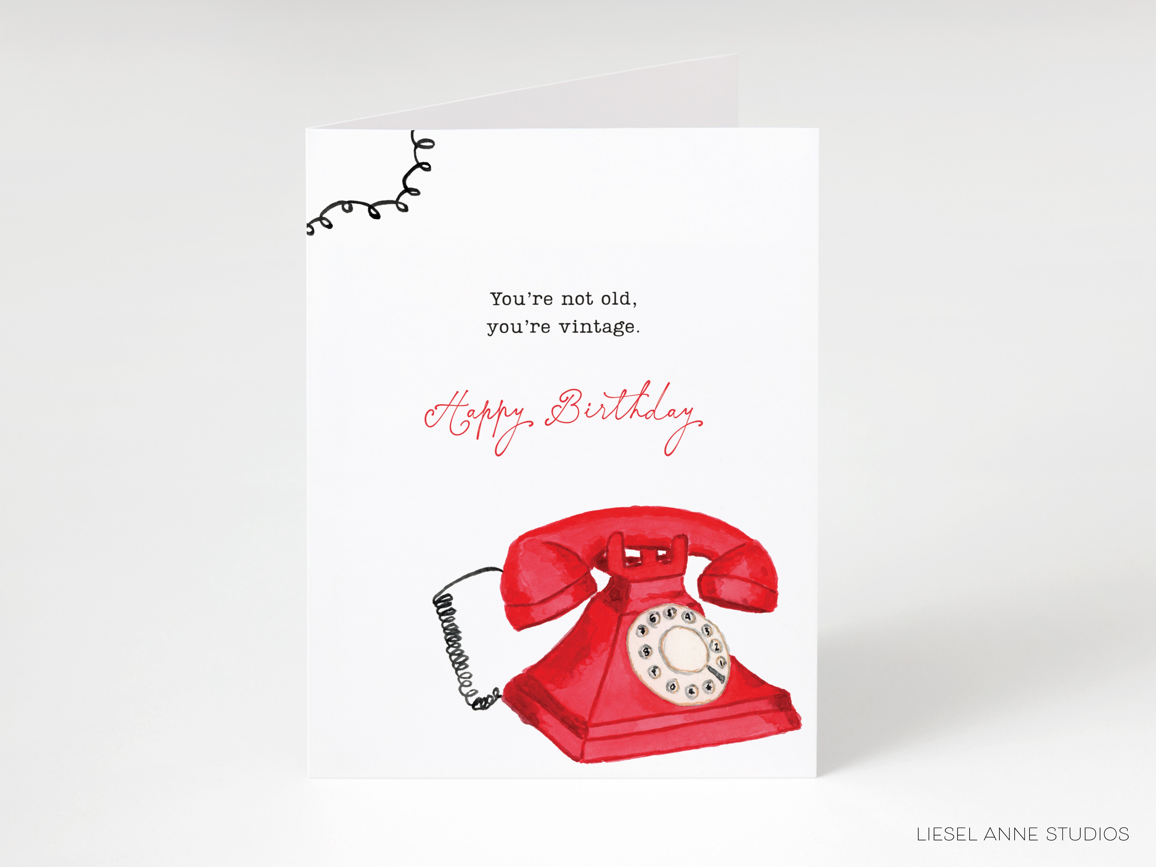A birthday card with a red rotary telephone on the front, and a message that reads "You're not old, you're vintage."