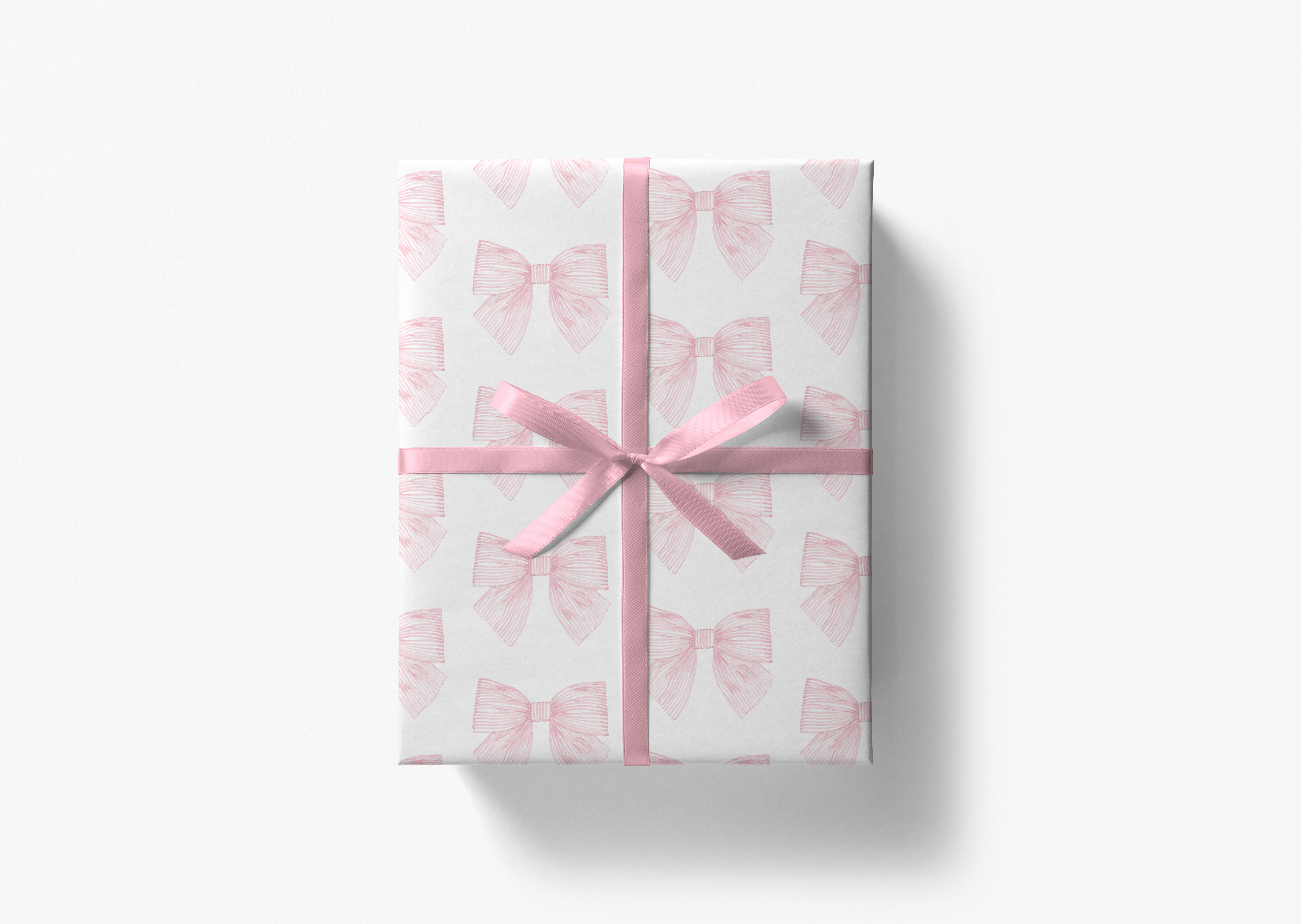 A gift box wrapped in pink paper with a pink ribbon bow tied around it.