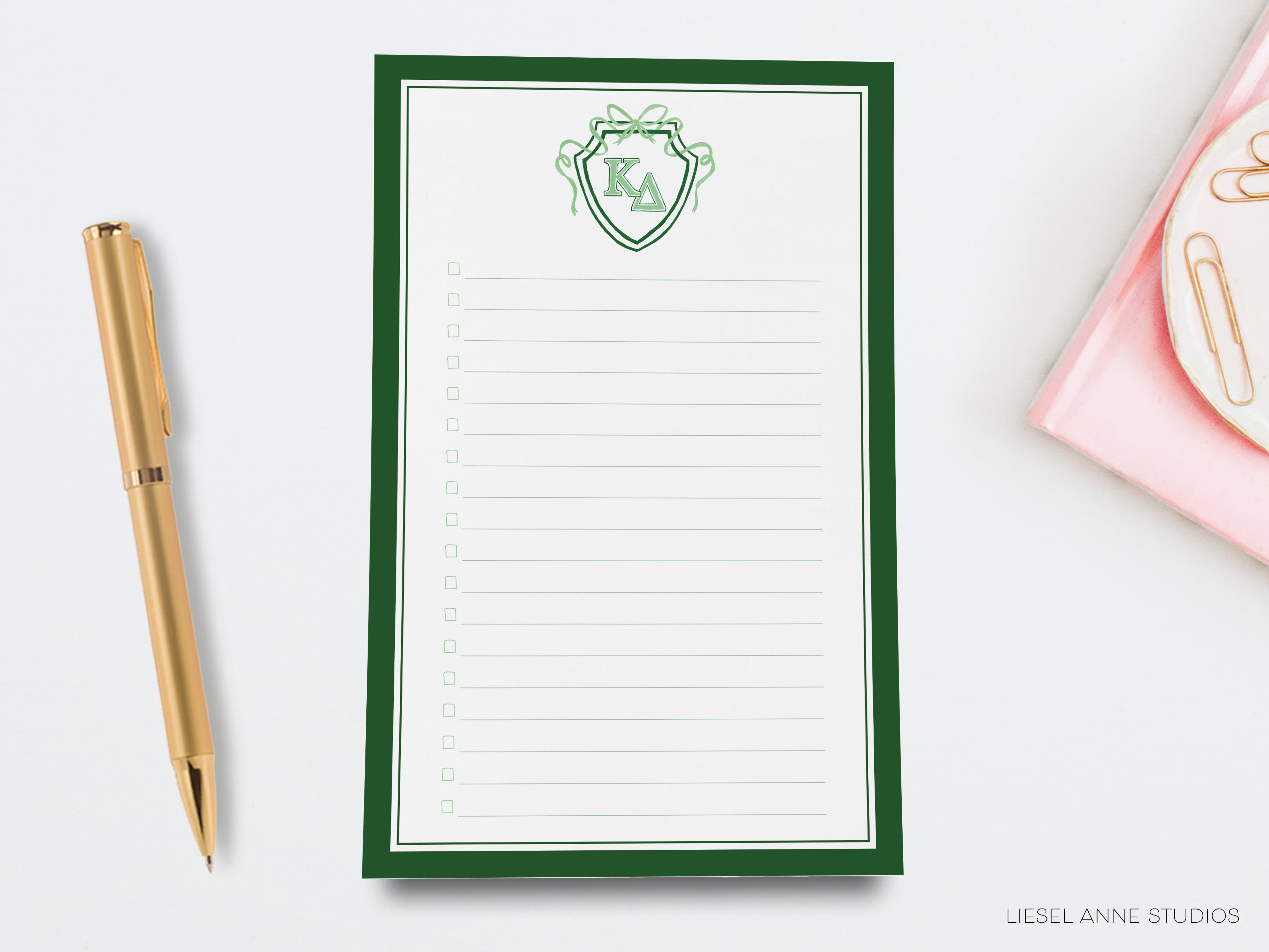 a notepad with a green and white design on it next to a pen and