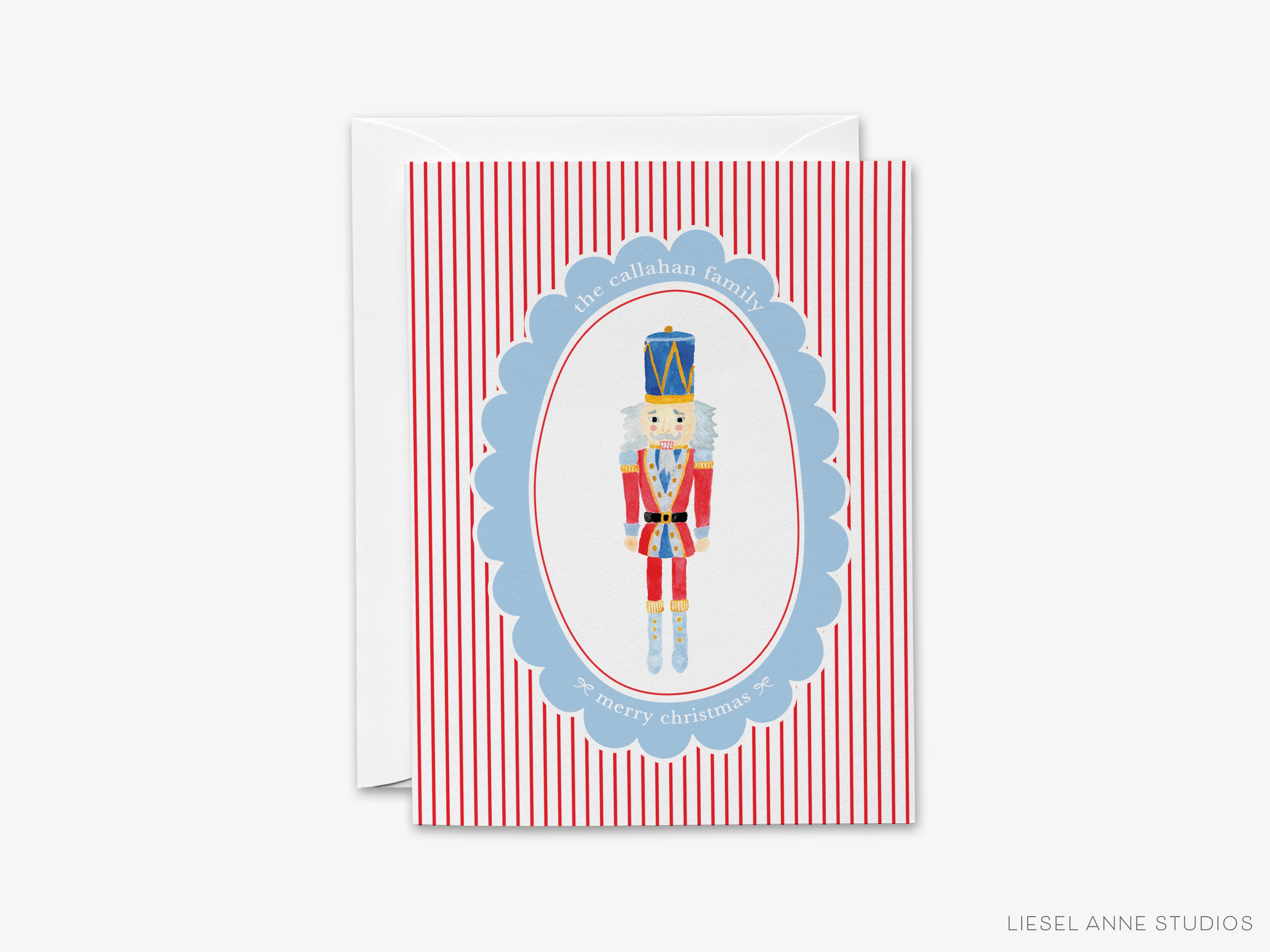 A greeting card featuring a nutcracker figure in a blue oval frame with a red and white striped background.