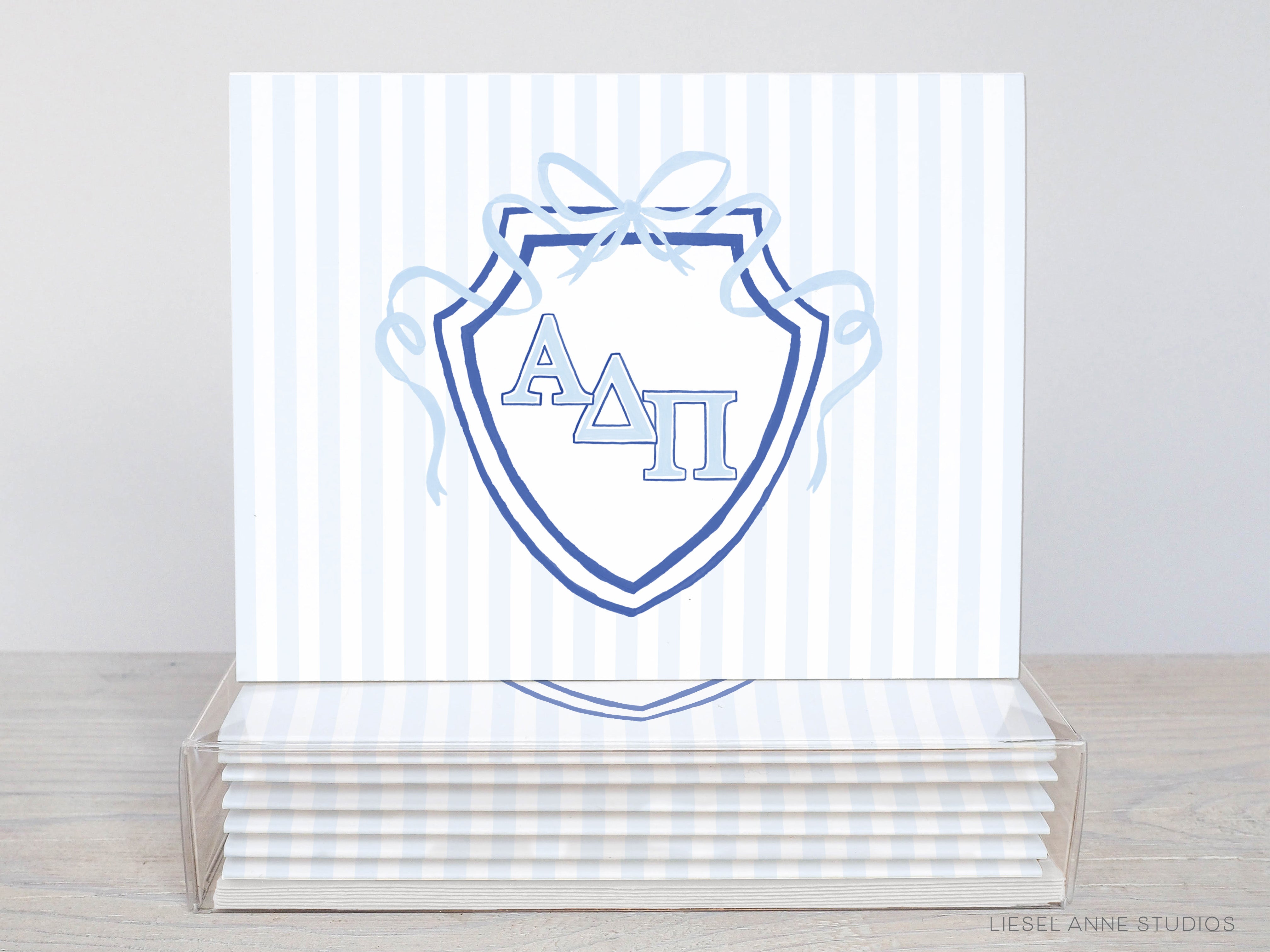 A stack of white greeting cards with a blue and white shield design featuring the letters 'A Delta' on the front.