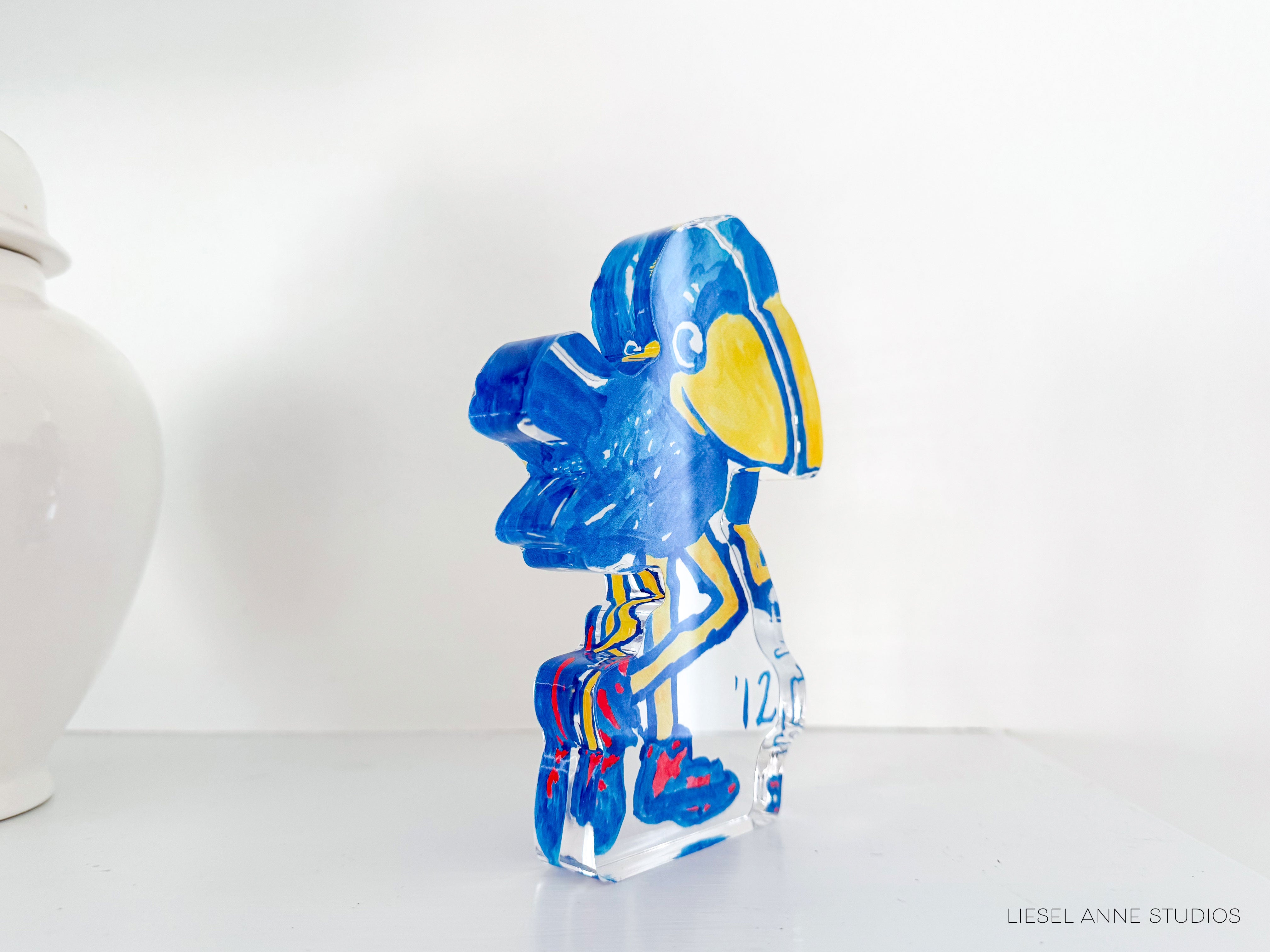 a glass figurine sitting next to a white vase