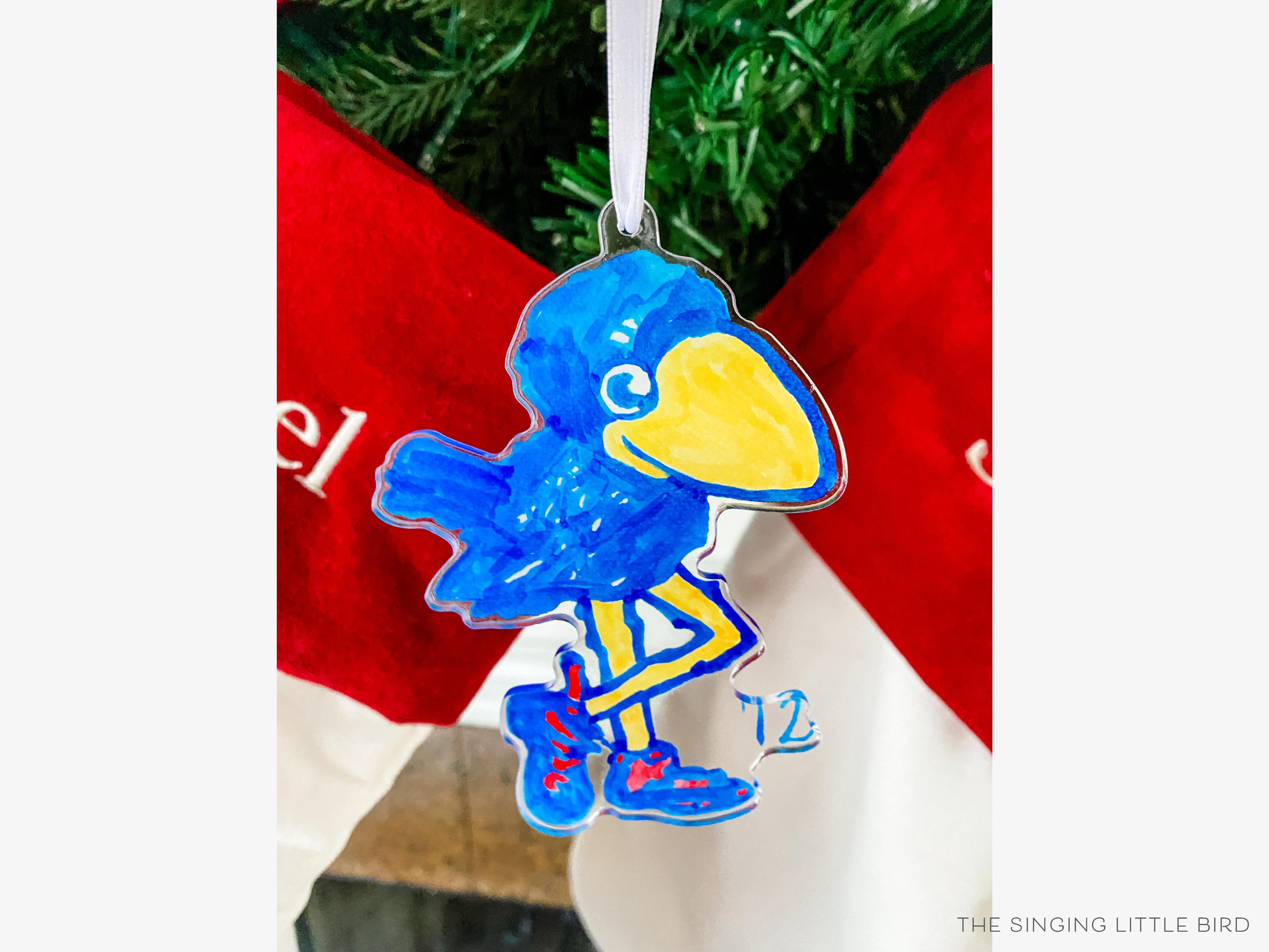 1912 Kansas Jayhawk Acrylic Ornament [Officially Licensed]-These acrylic ornaments feature our hand-painted watercolor 1912 Kansas Jayhawk. They include a white silk ribbon and measure approximately 4" on its longest side, making a great addition to your Christmas tree or gift for the University of Kansas lover in your life.-The Singing Little Bird