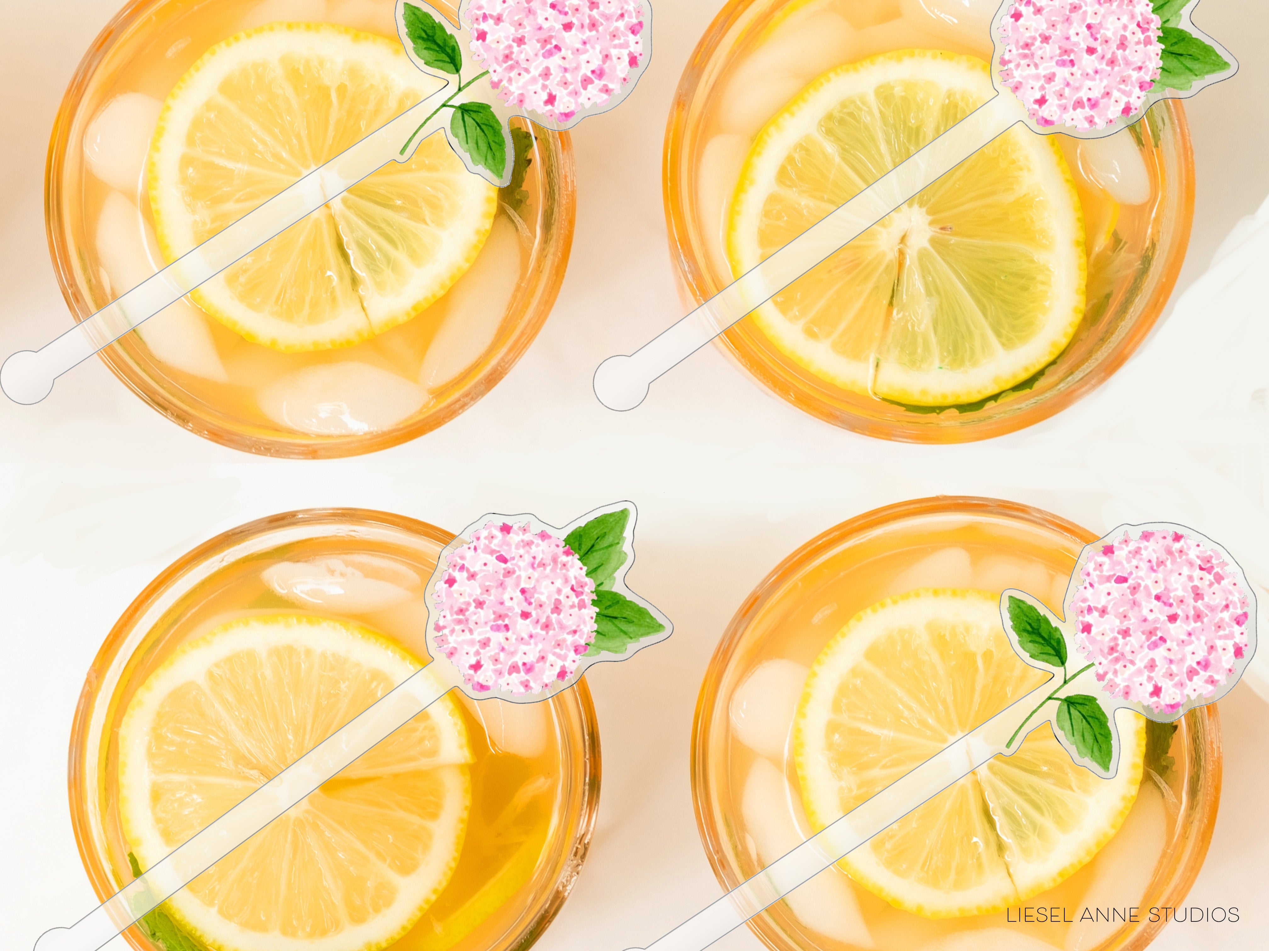 four glasses filled with a yellow liquid, each containing a slice of lemon and a pink flower decoration.