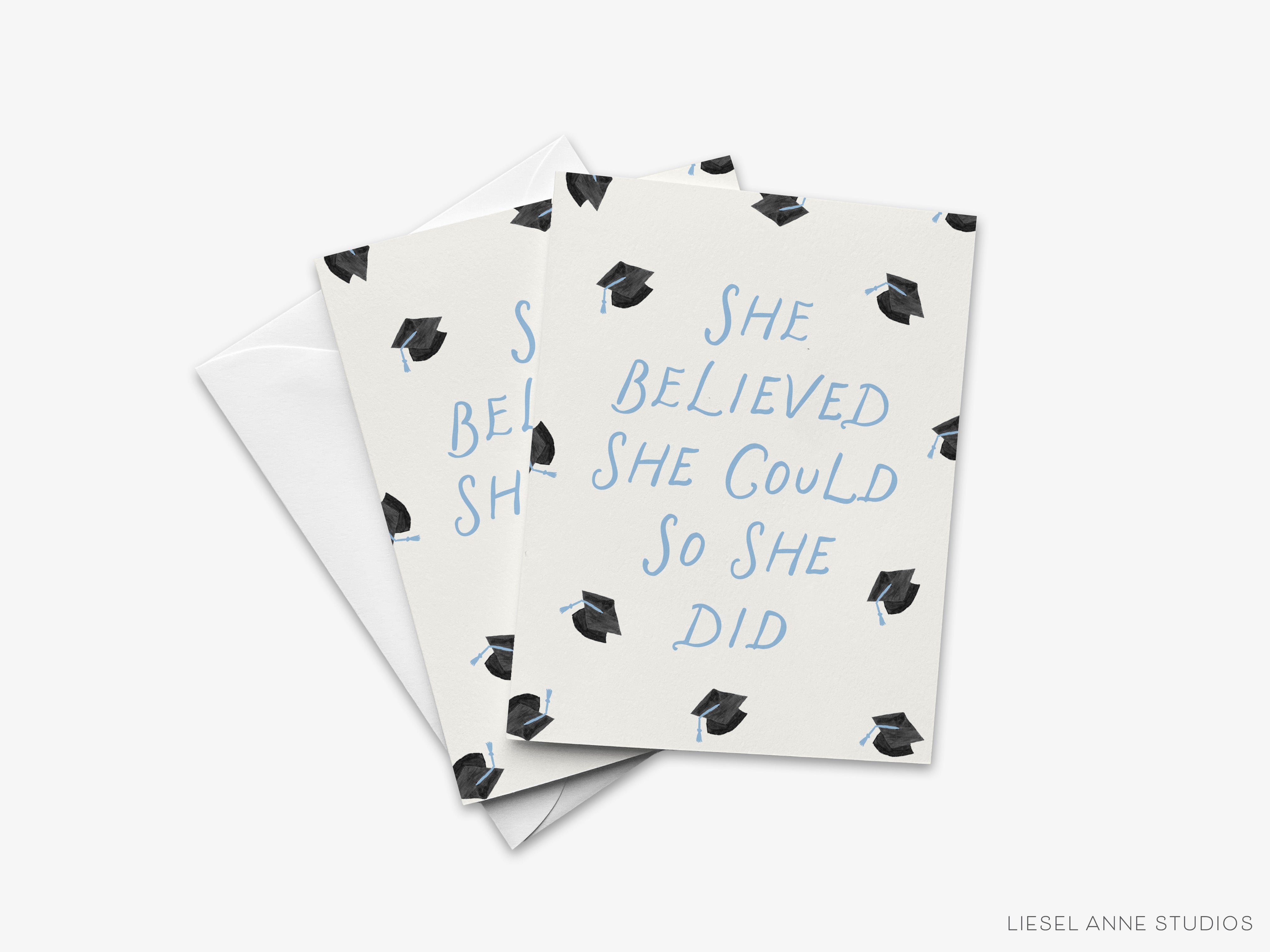 A greeting card with a graduation cap pattern and the text "She believed she could so she did" printed on it.
