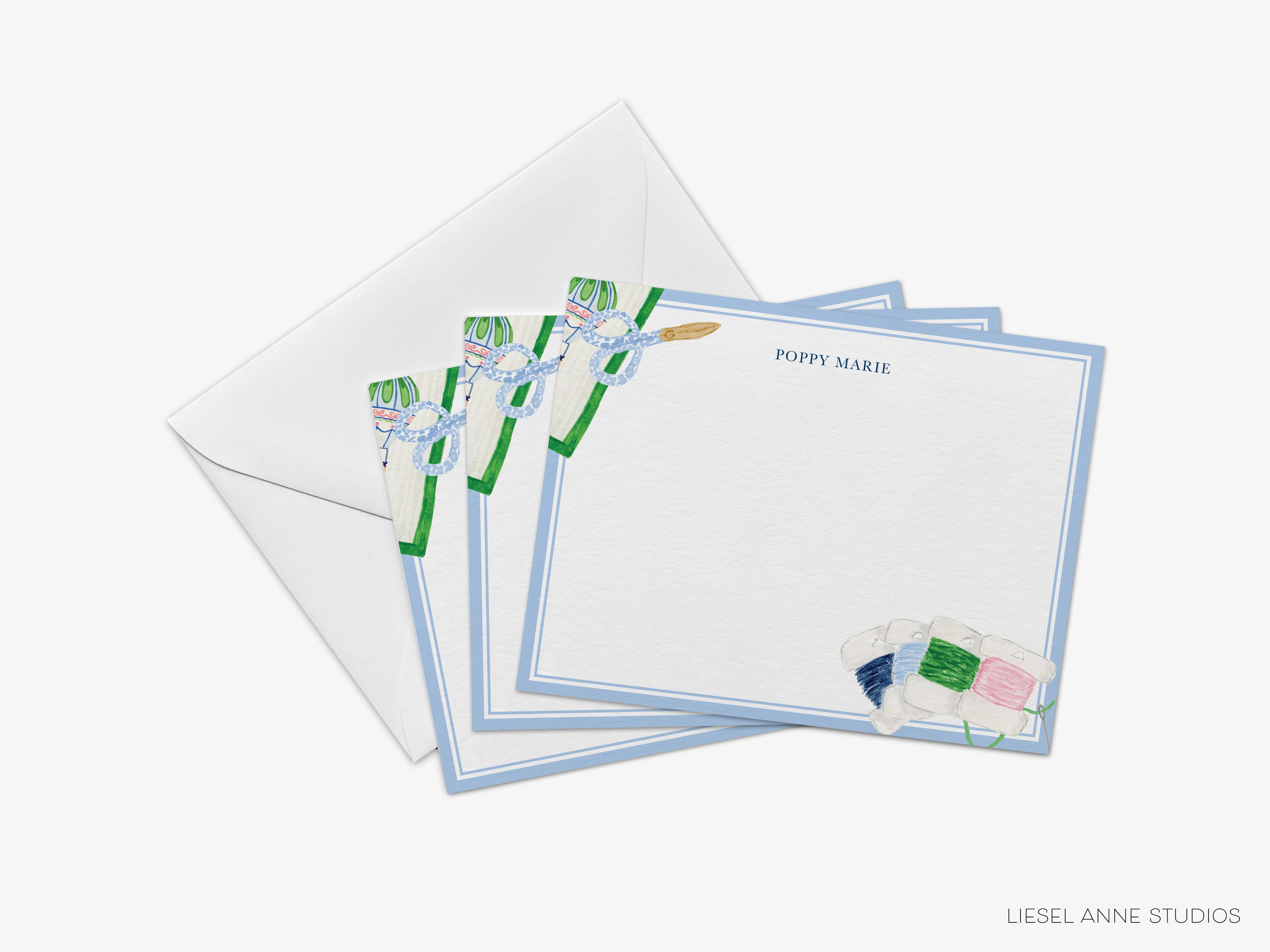 a set of personalized stationery with a blue and white color scheme, including a blank card and an envelope.
