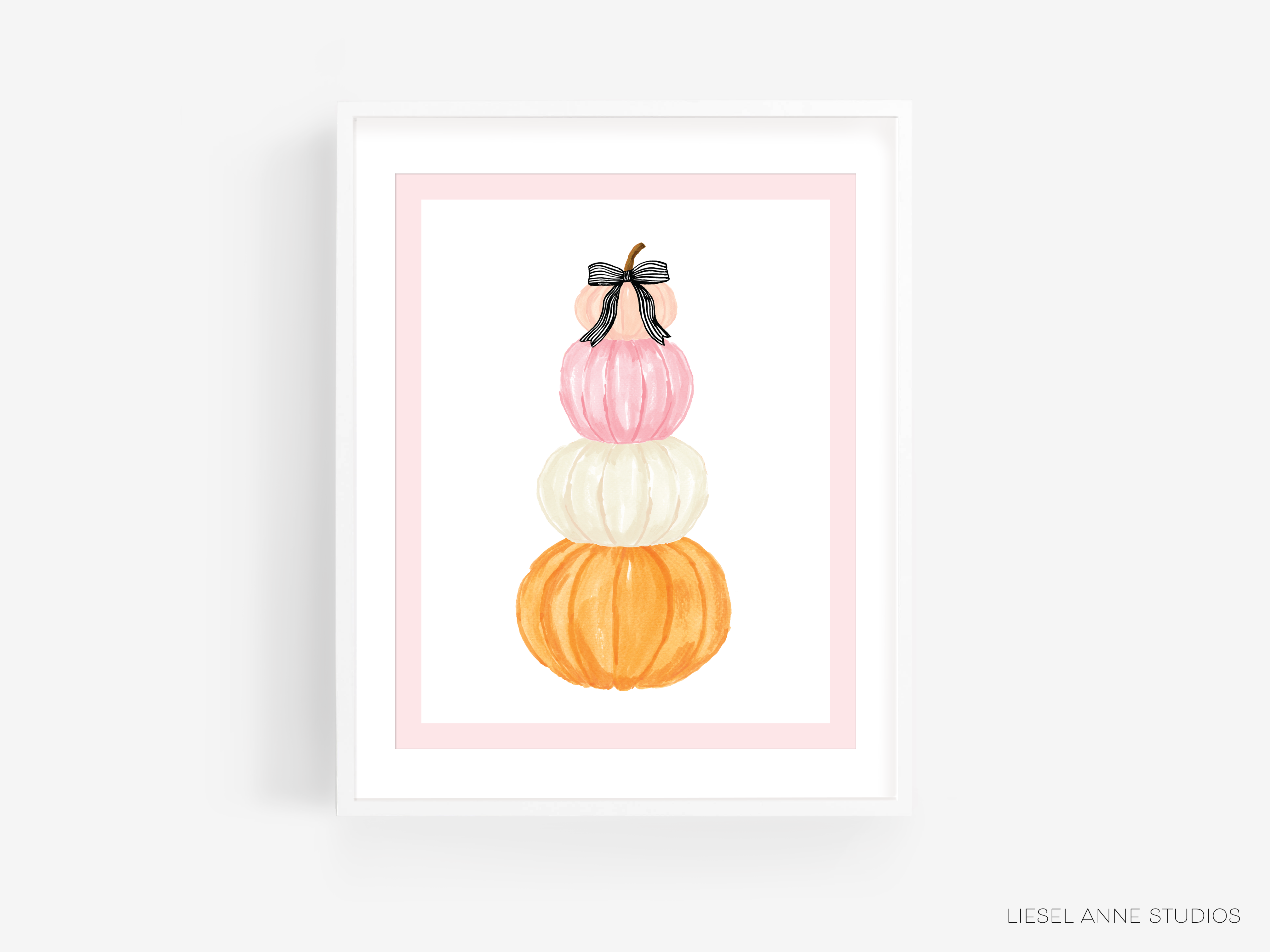 A framed illustration of three stacked pumpkins in different colors - pink, white, and orange.