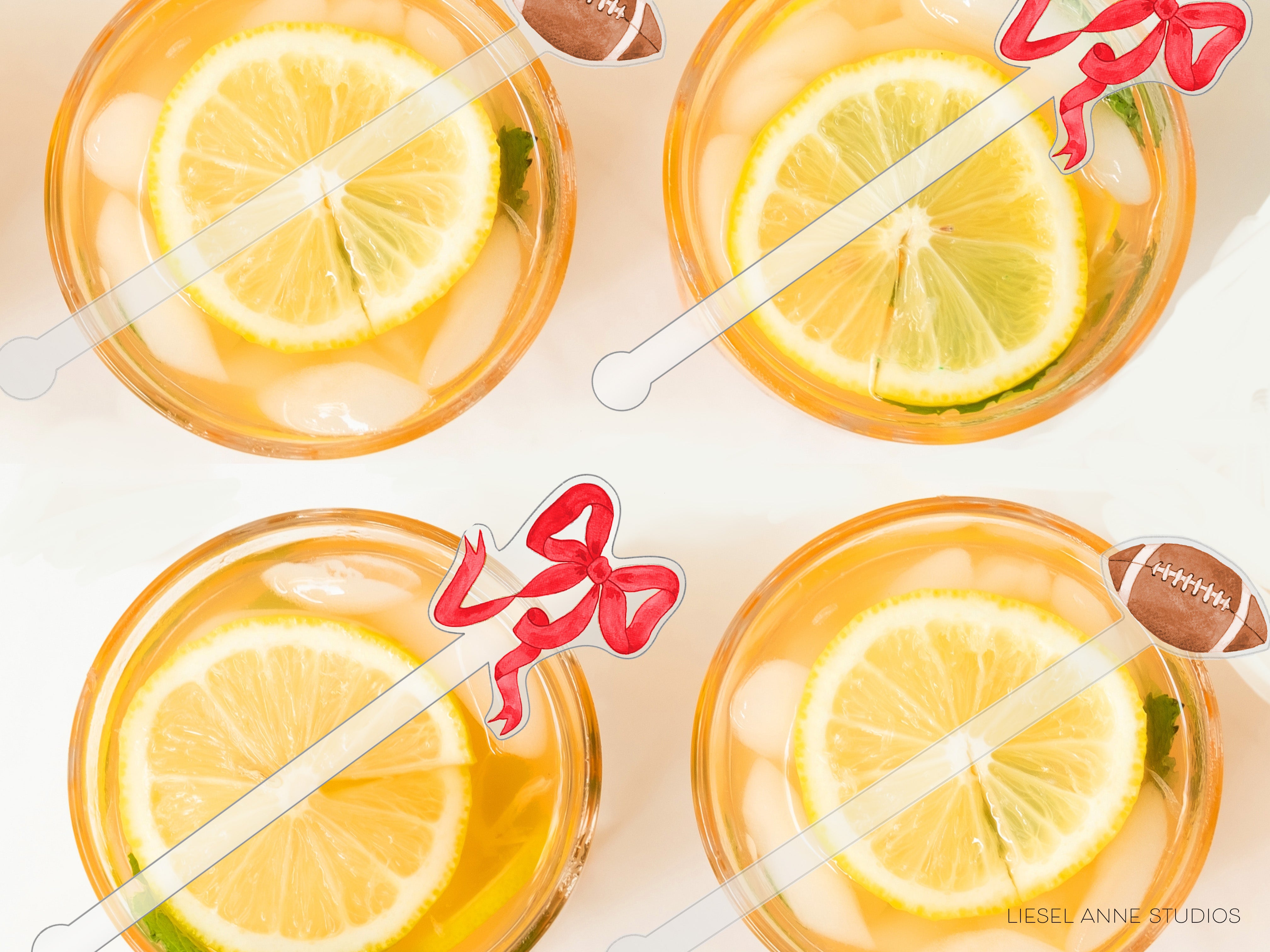 four glasses filled with a yellow liquid, each containing a slice of lemon and a football-shaped straw.