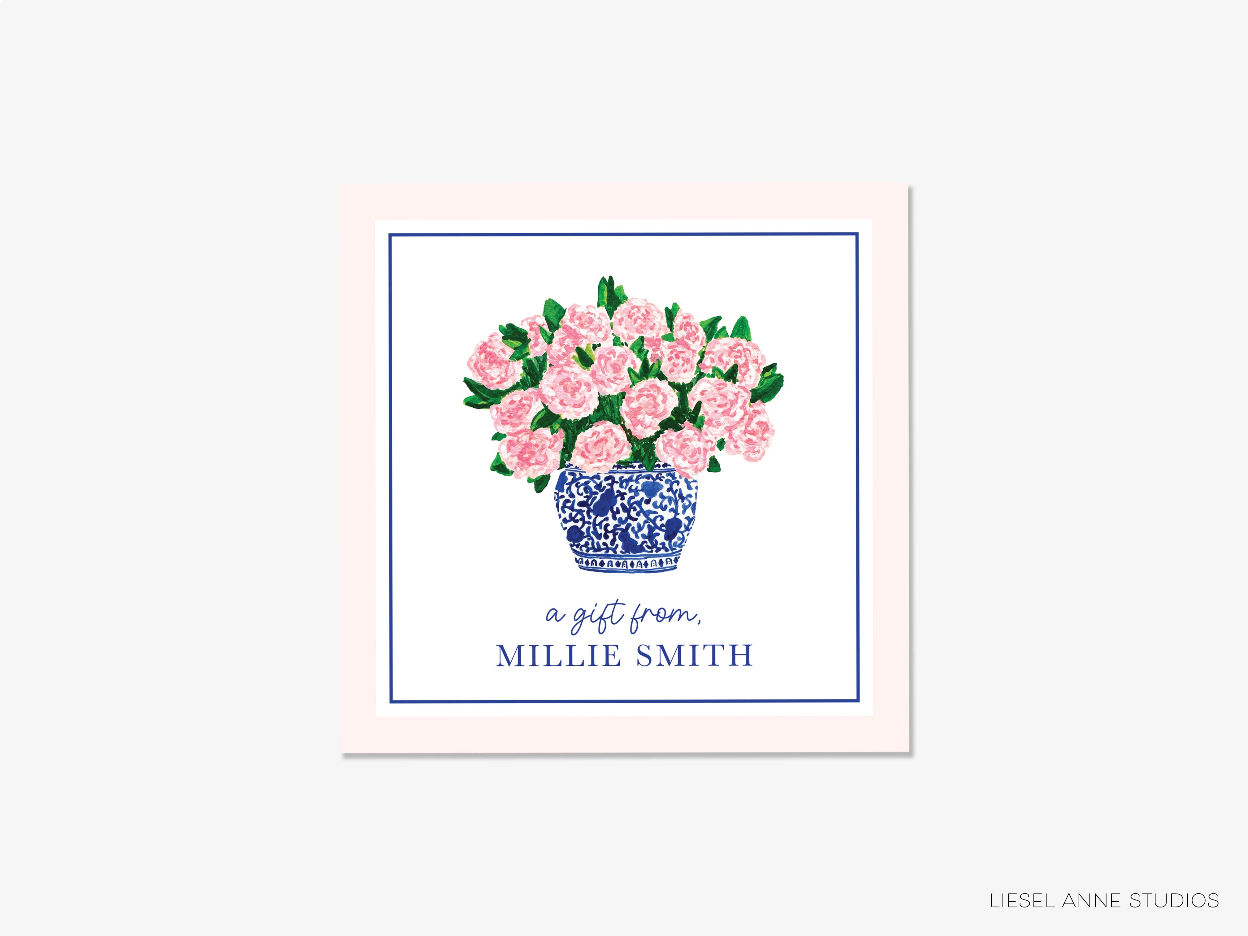 a blue and white vase filled with pink flowers