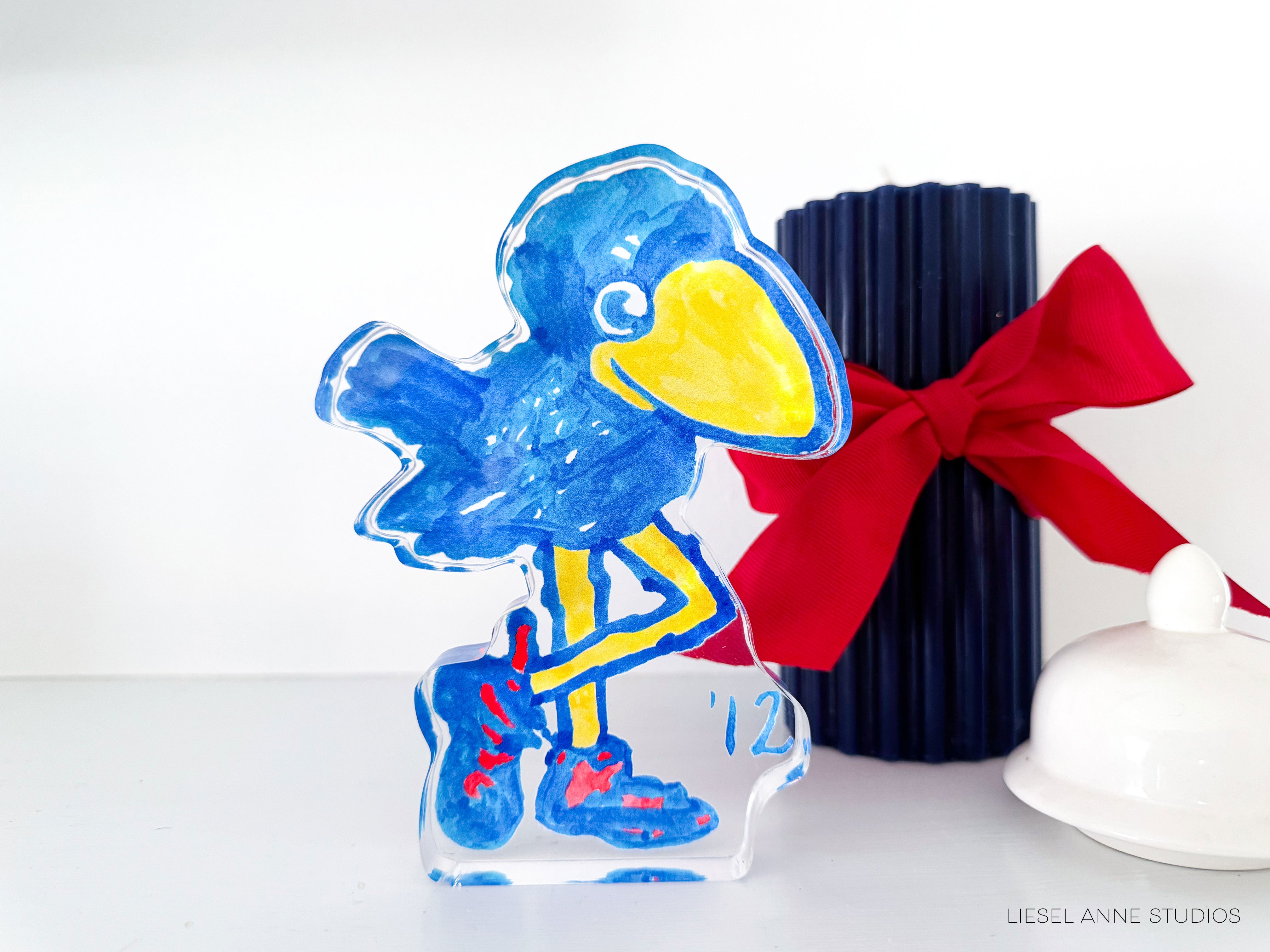 a glass figurine of a blue bird with a red bow