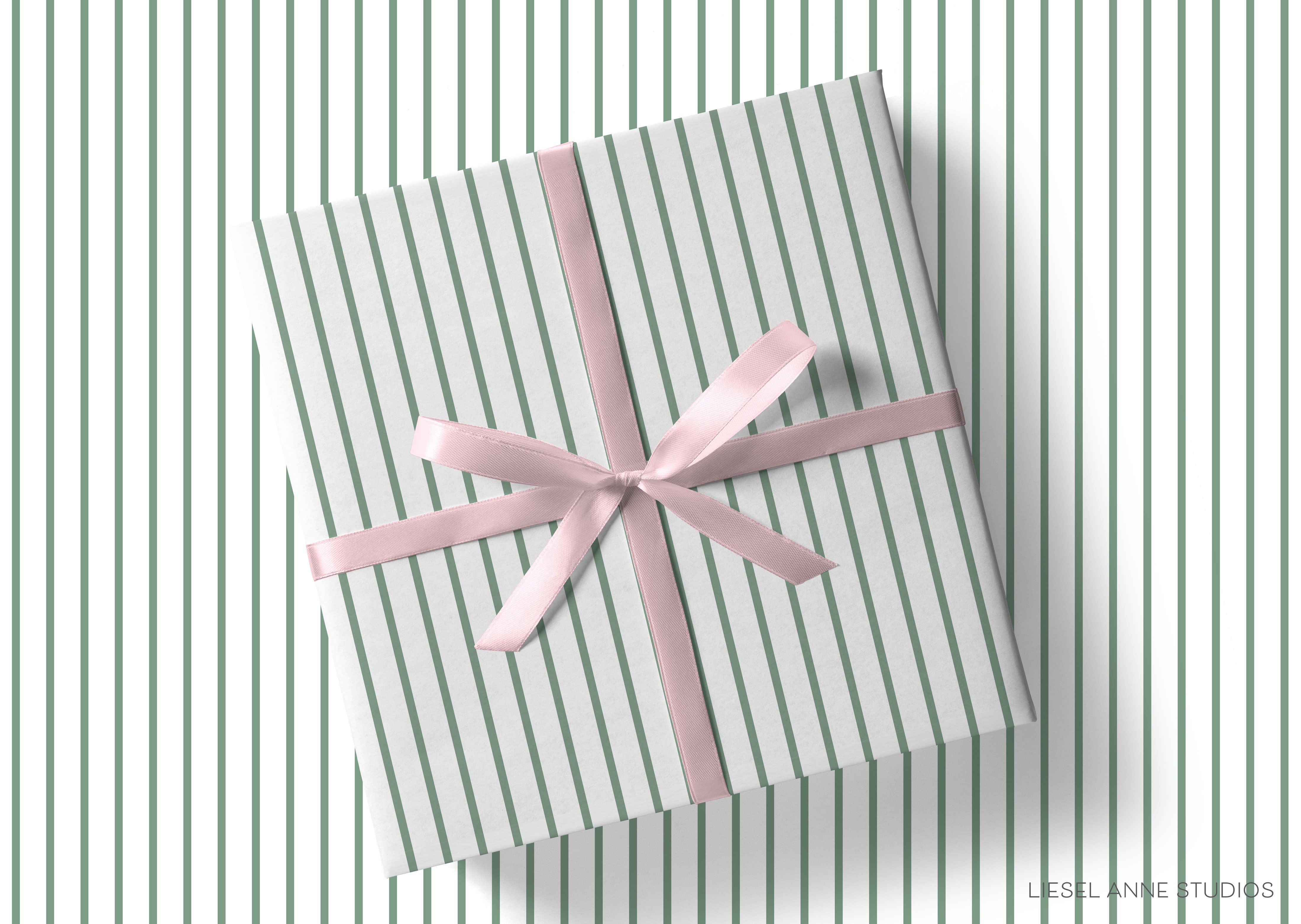 A gift box wrapped in a striped green and white paper with a pink ribbon tied around it, placed on a white background.