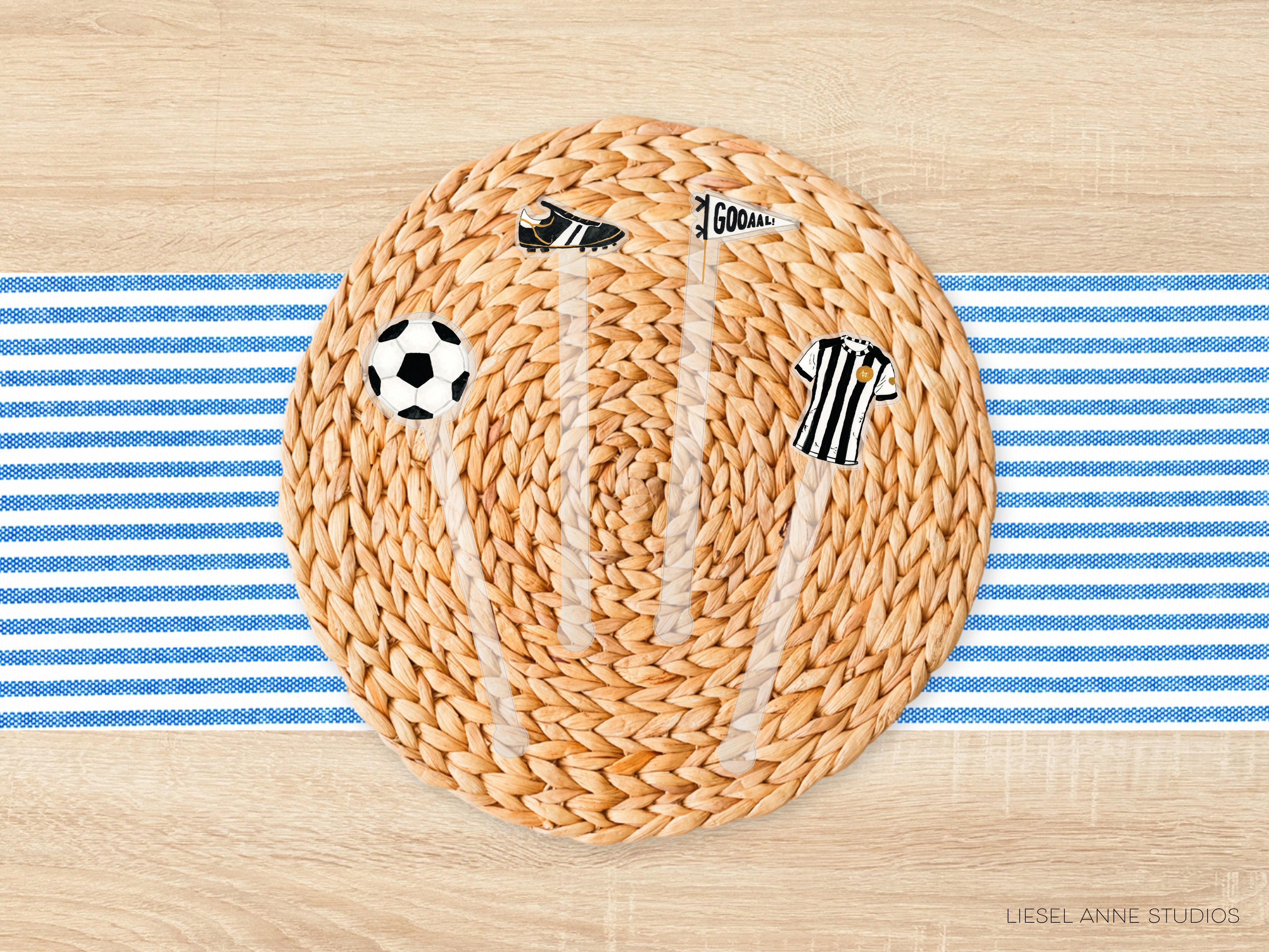 A woven placemat with a soccer ball, flag, and striped shirt on it, placed on a blue and white striped tablecloth.