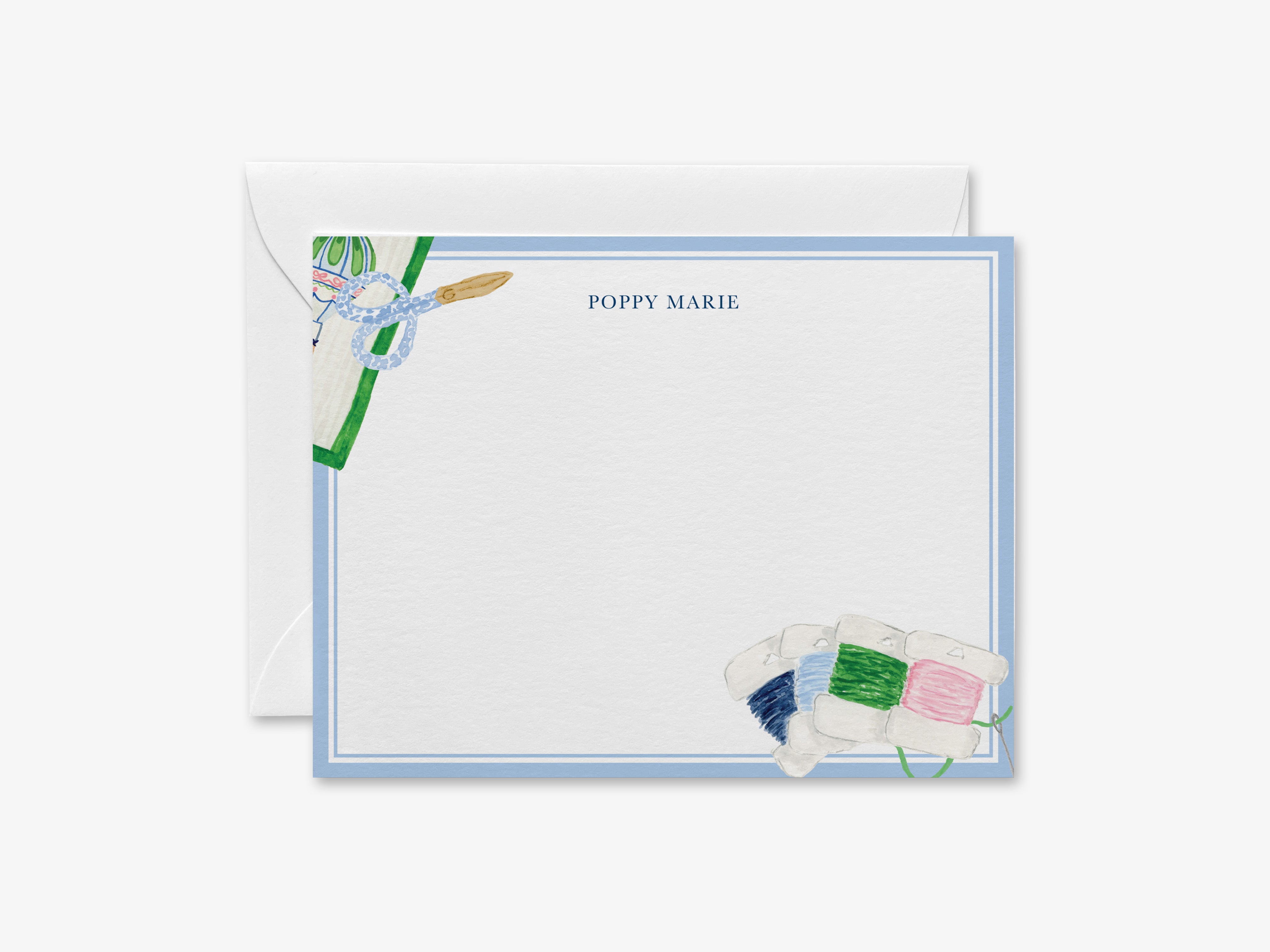 The image is a personalized note card with a blue border and illustrations of sewing supplies, including spools of thread and a pair of scissors.
