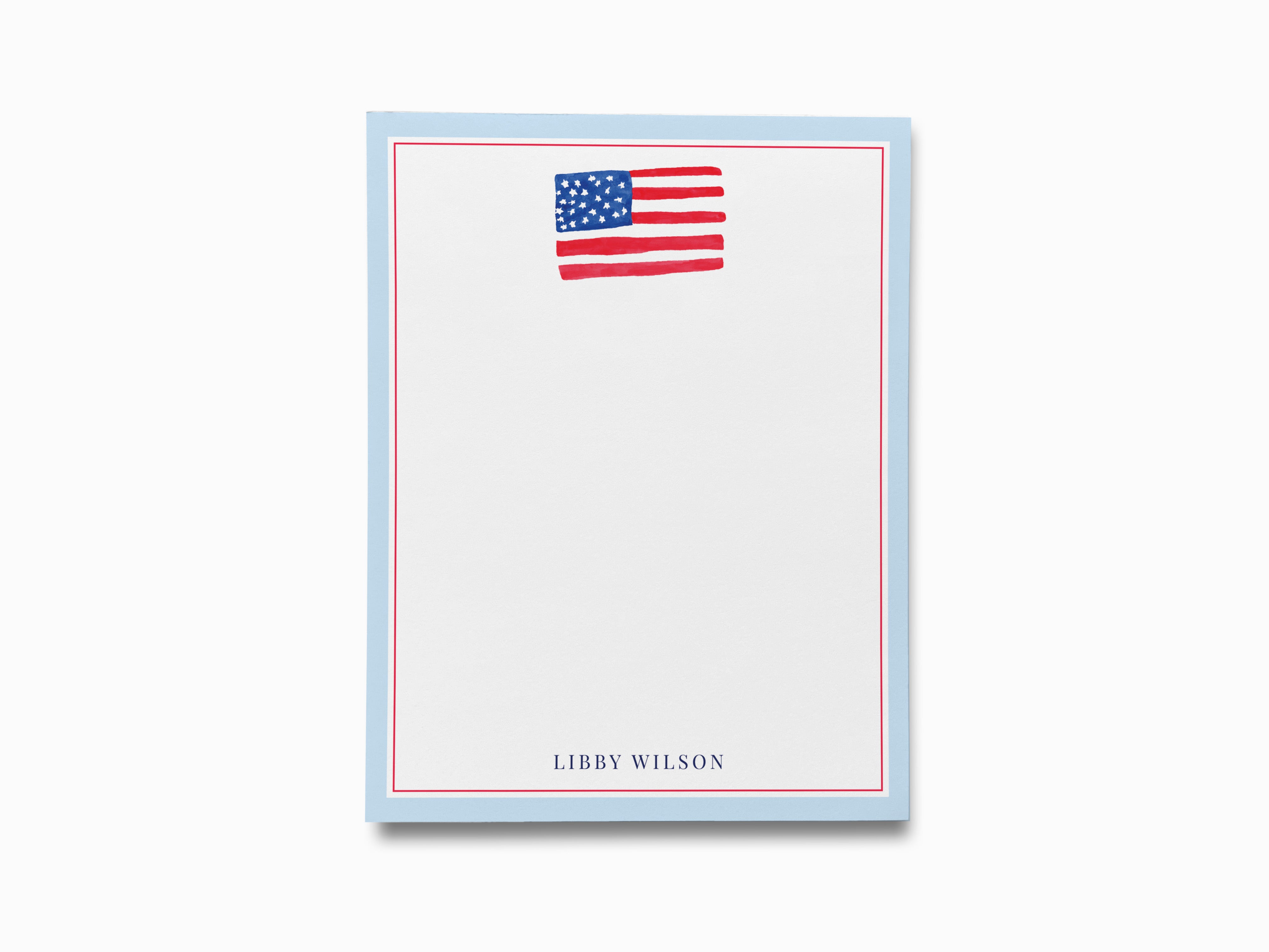 a blue notepad with a picture of the American flag on the top right corner.