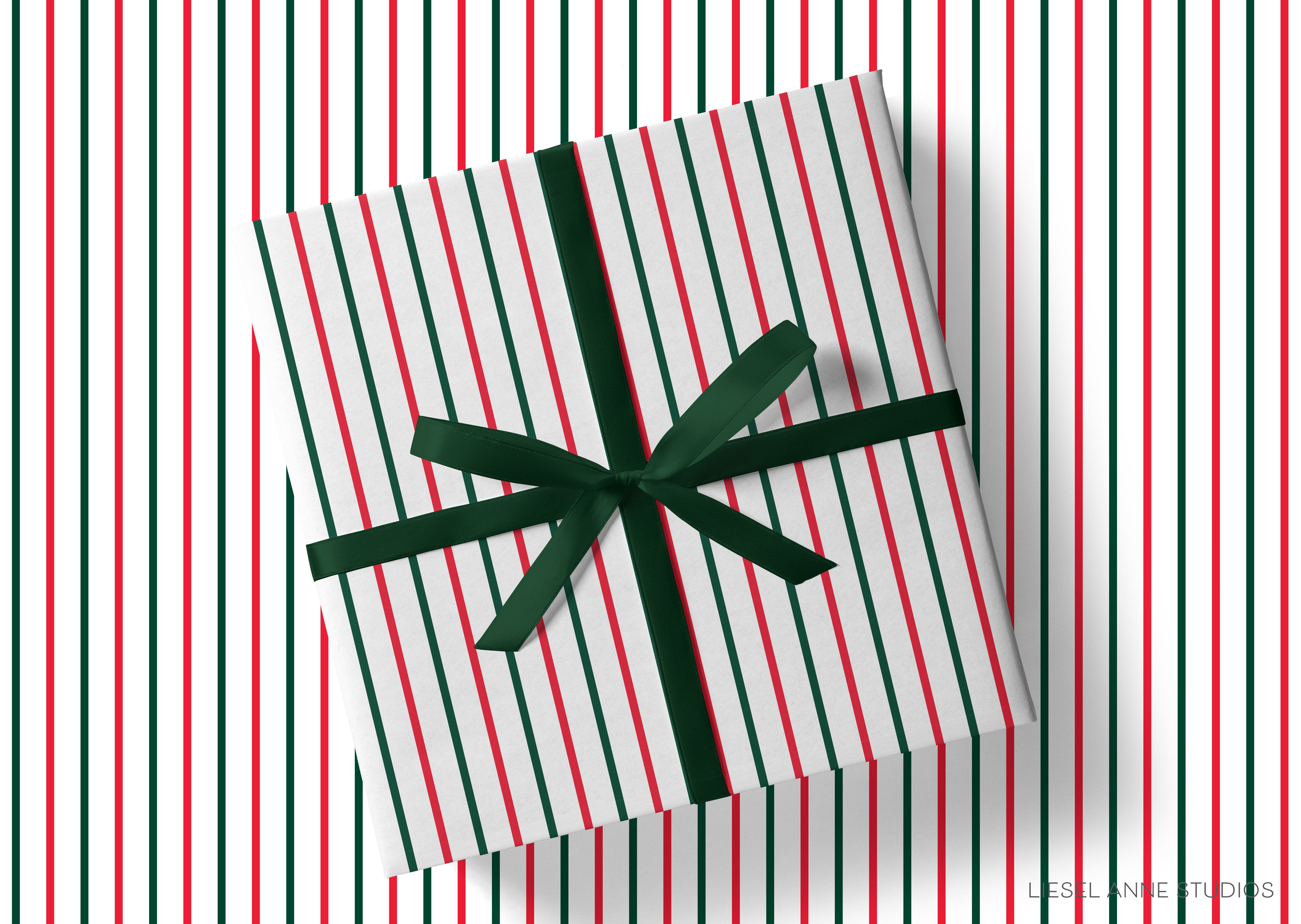 A gift box with a green ribbon tied around it, placed on a background with red and green striped patterns.
