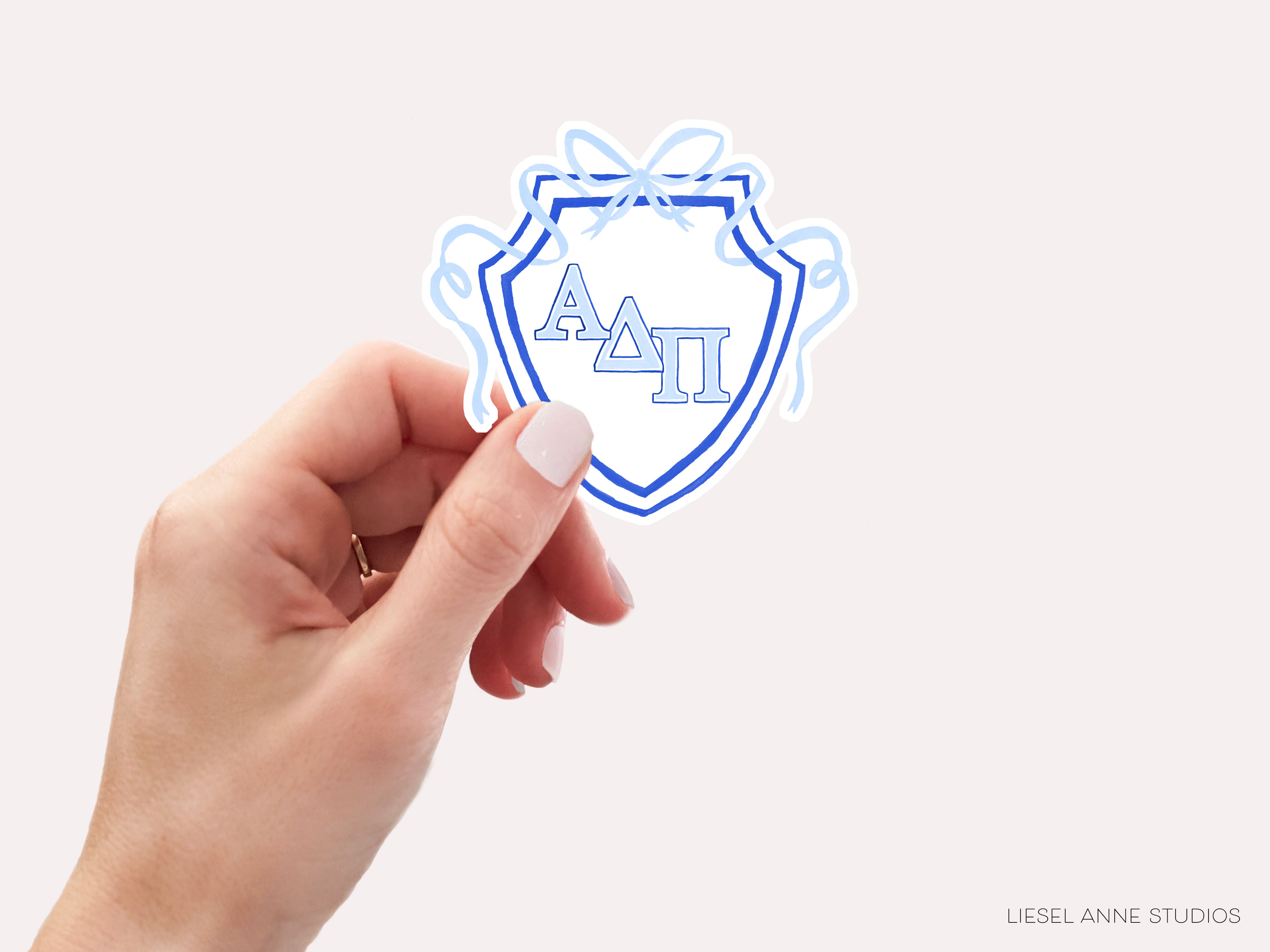 a hand holding a sticker with the letter a in it