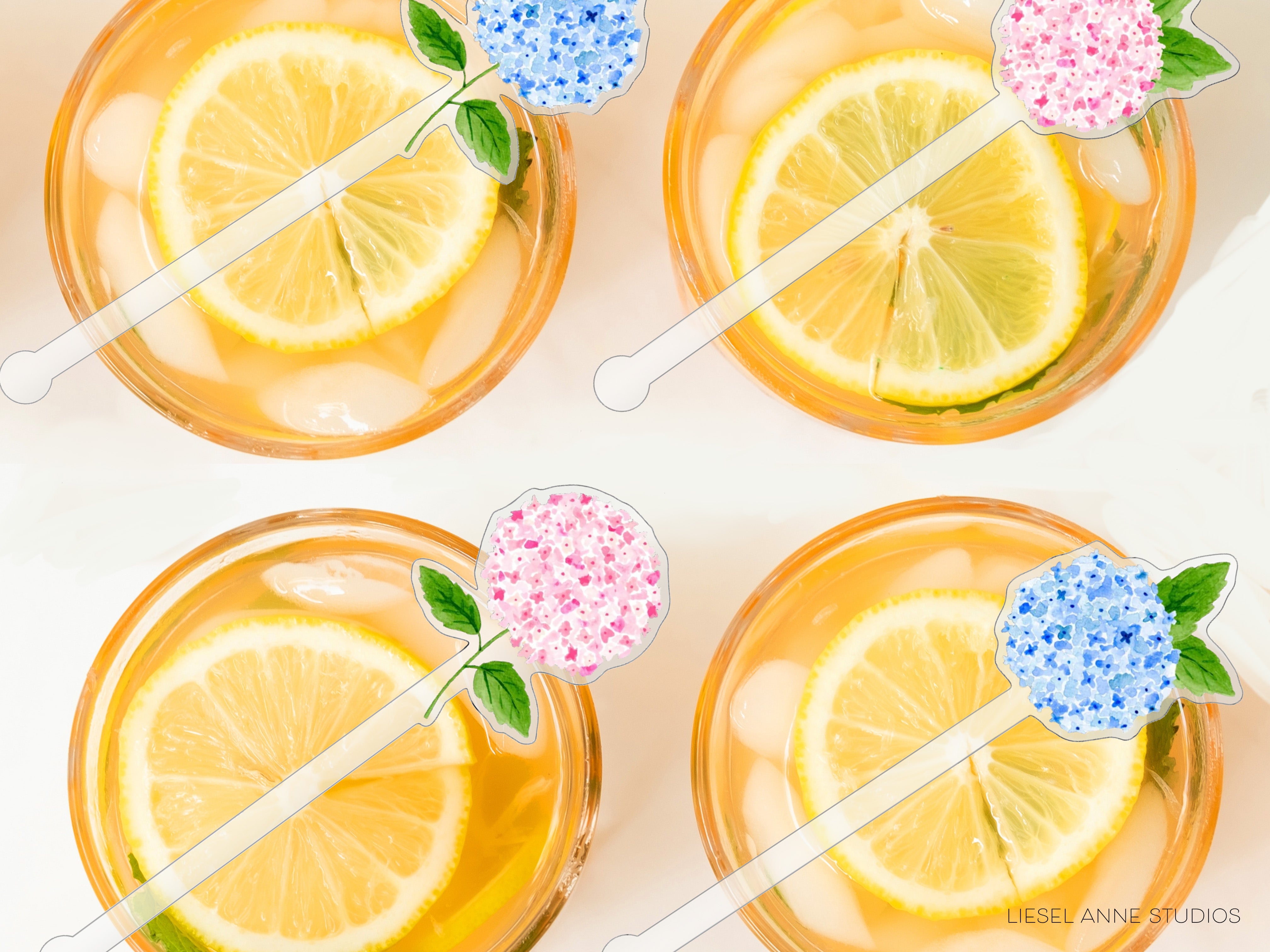 four glasses filled with a yellow liquid, each containing a slice of lemon and a blue flower decoration.