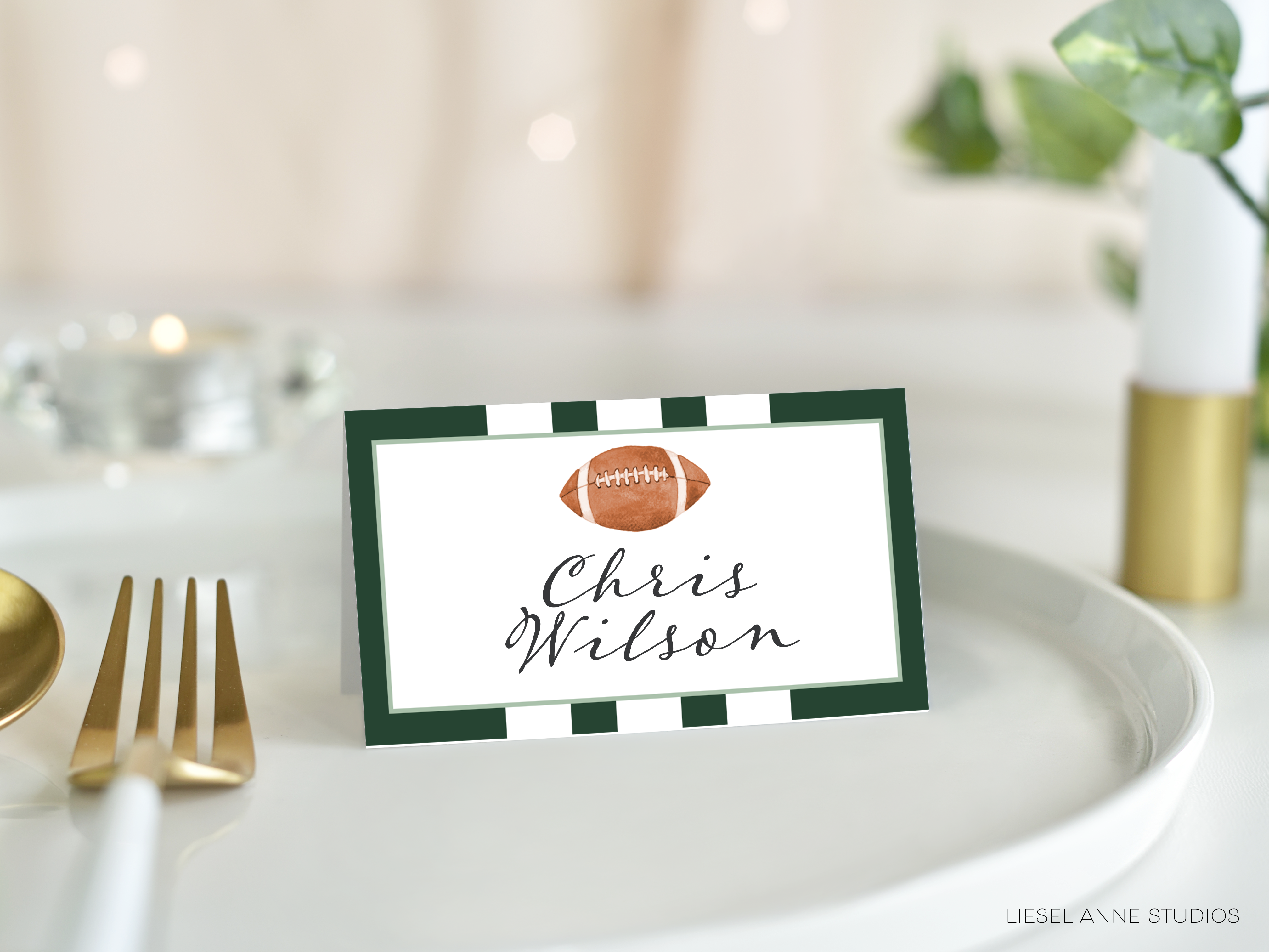 A place card with a football on it, placed on a white tablecloth.