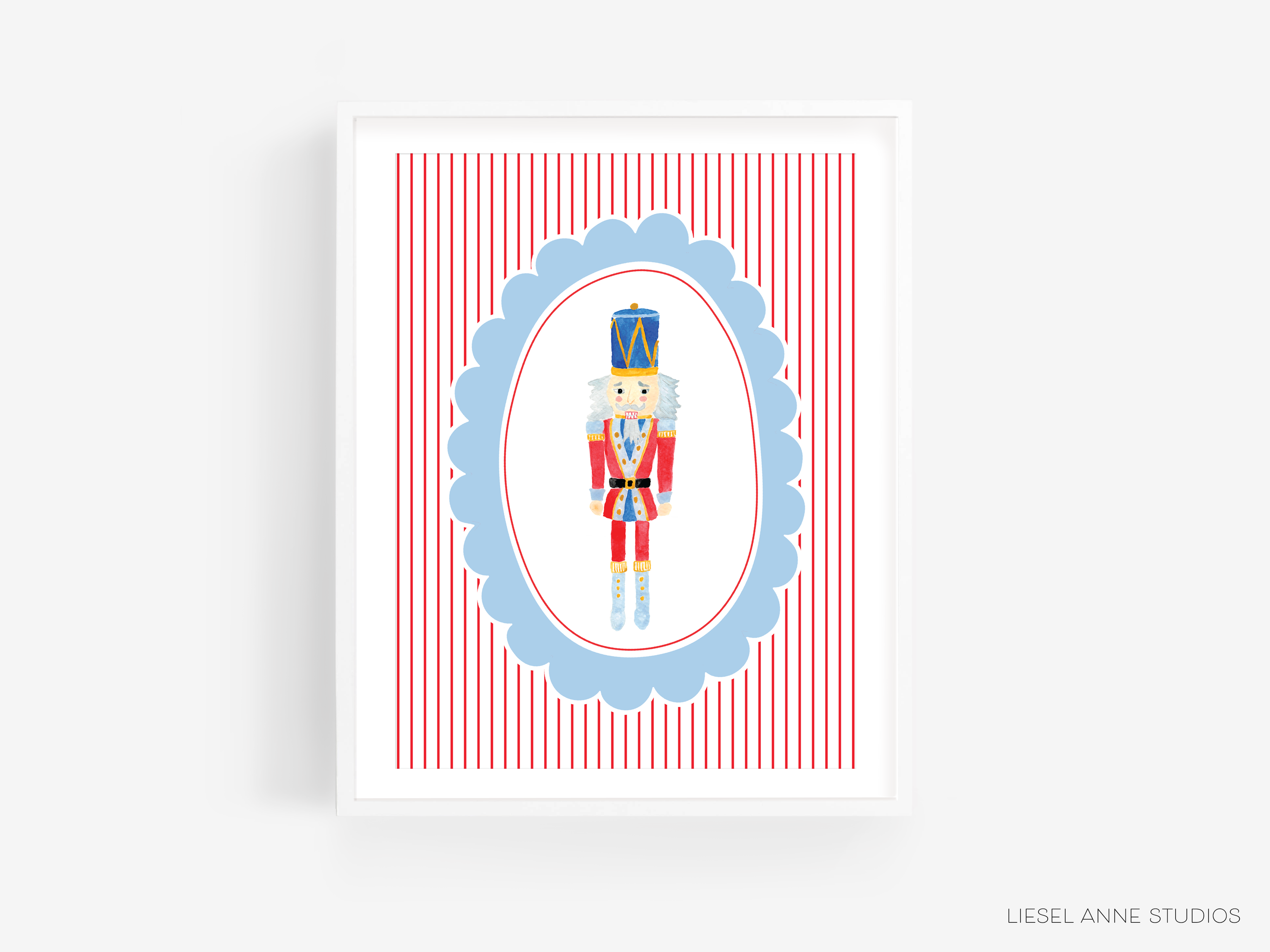 A framed illustration of a nutcracker figure in a red and blue striped frame.