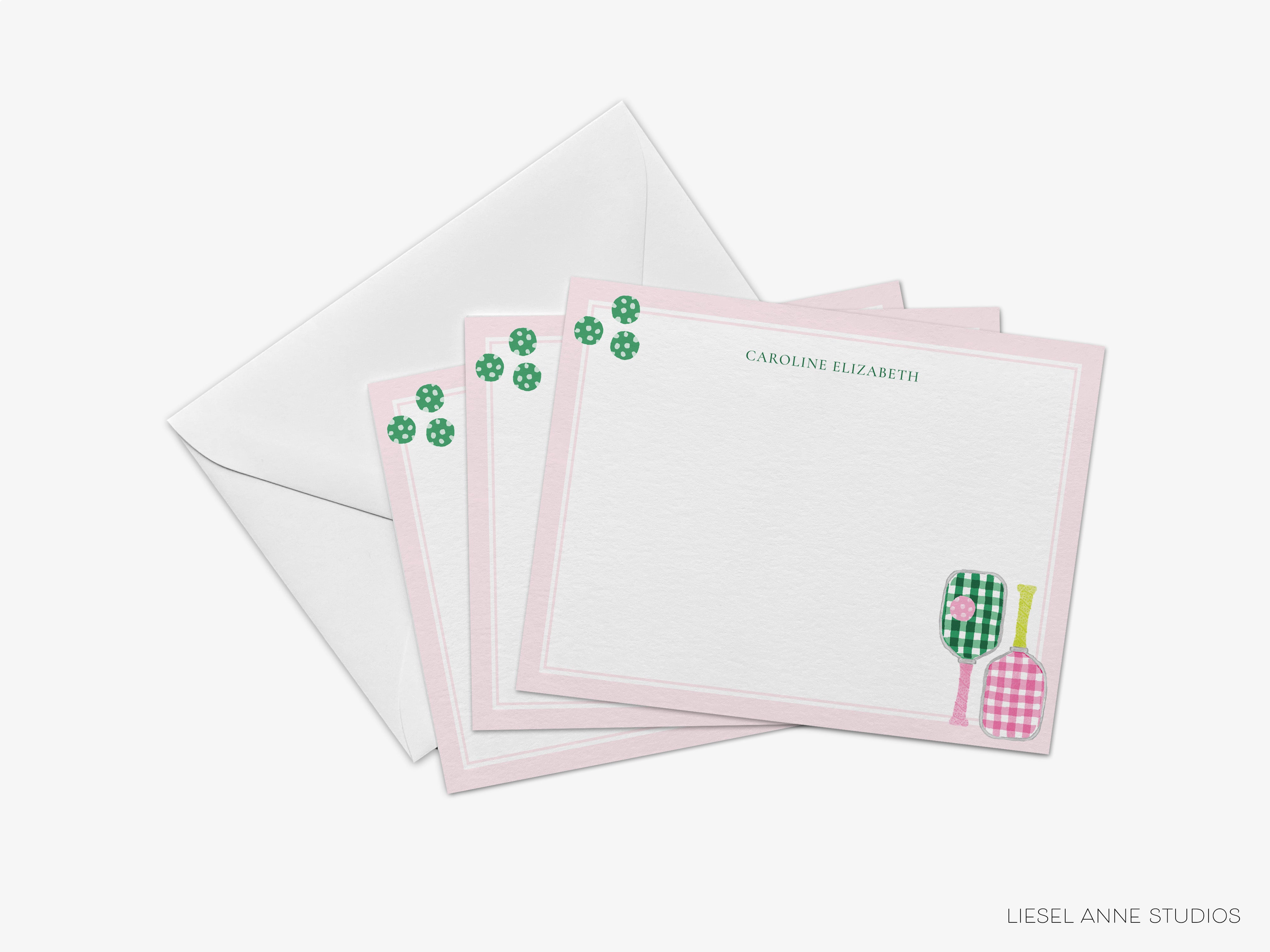 a set of personalized stationery cards with a pink and green color scheme. The cards are arranged in a way that they are placed on top of an envelope, creating a visually appealing presentation.