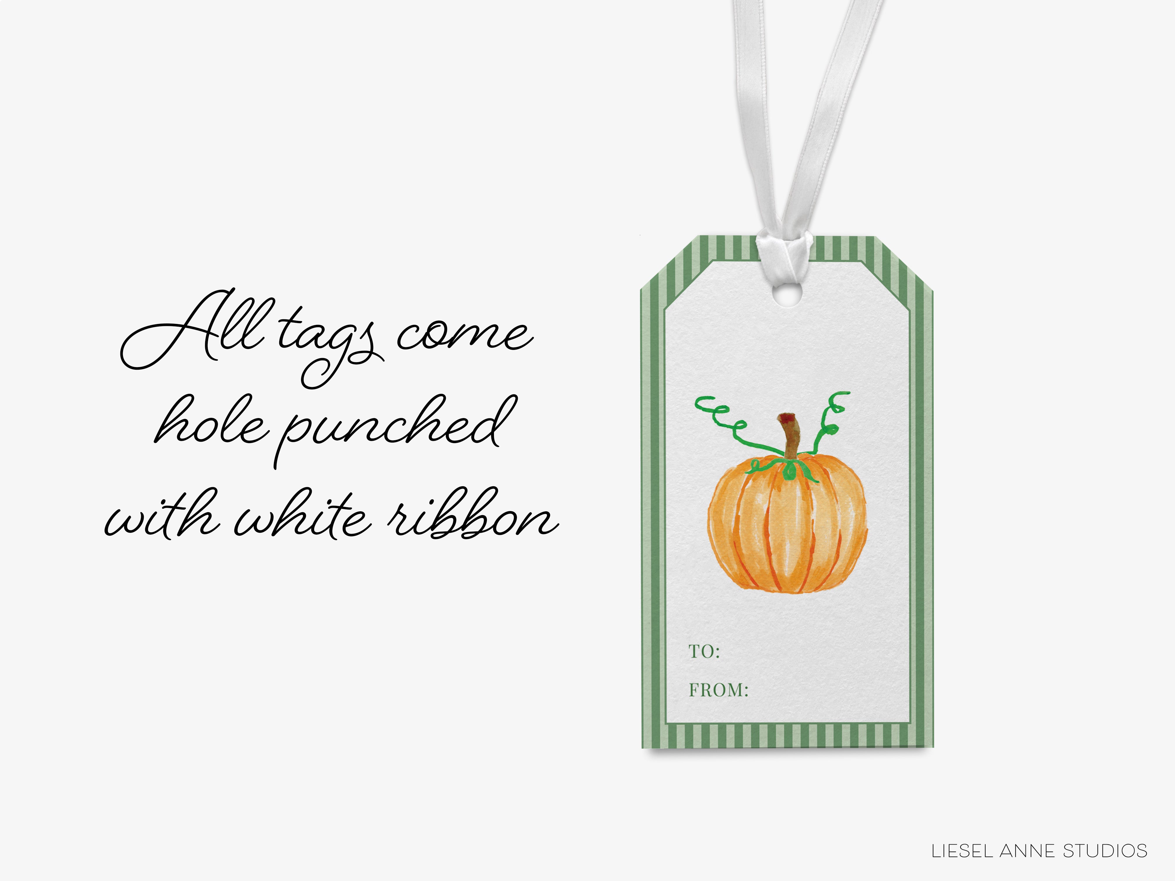 A white ribbon tag with a pumpkin illustration and text that reads "All tags come hole punched with white ribbon" and "To: FROM: LIESEL-ANNE STUDIOS".