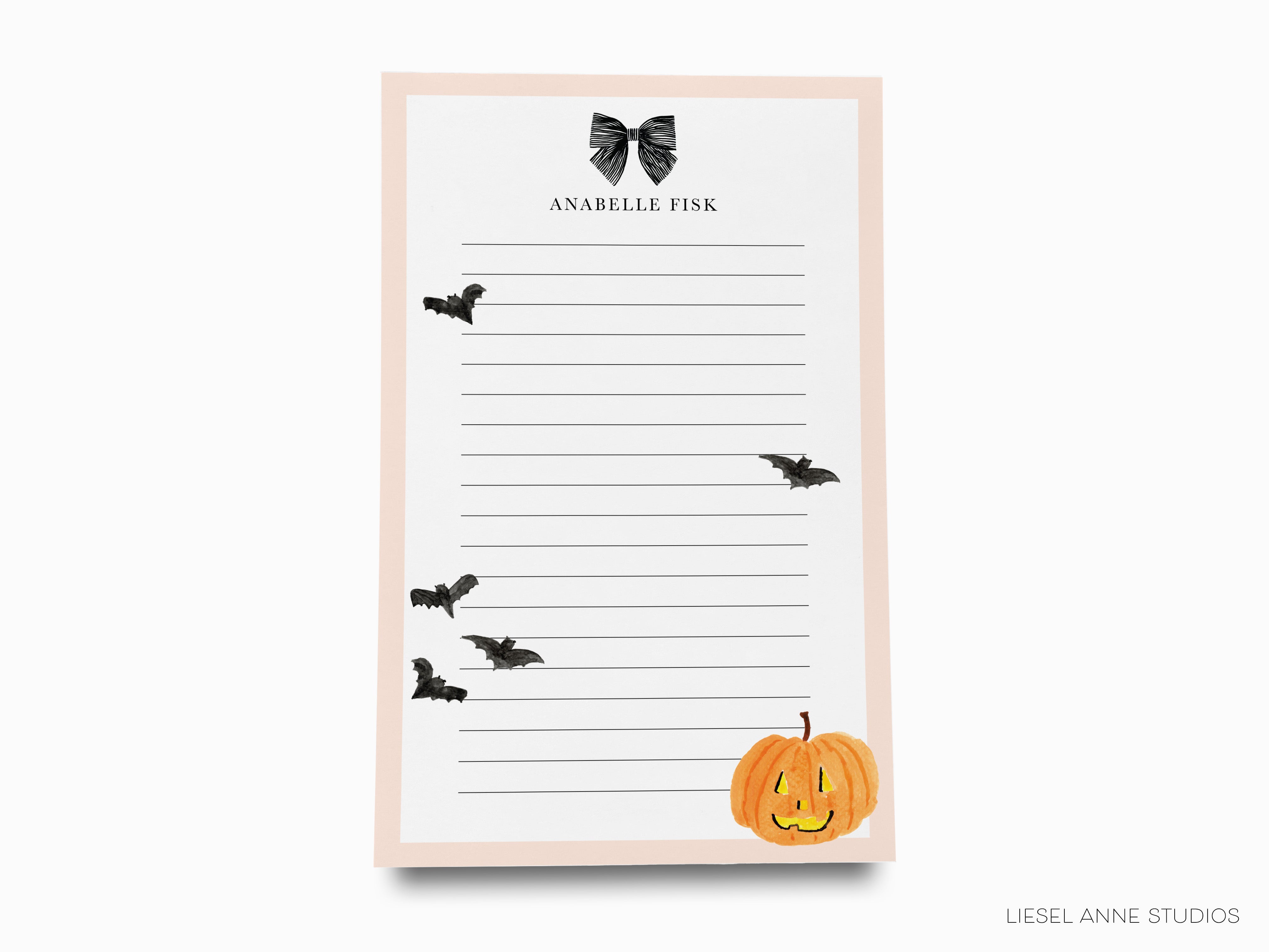 The image is a blank notepad with a Halloween-themed design, including bats and a pumpkin.