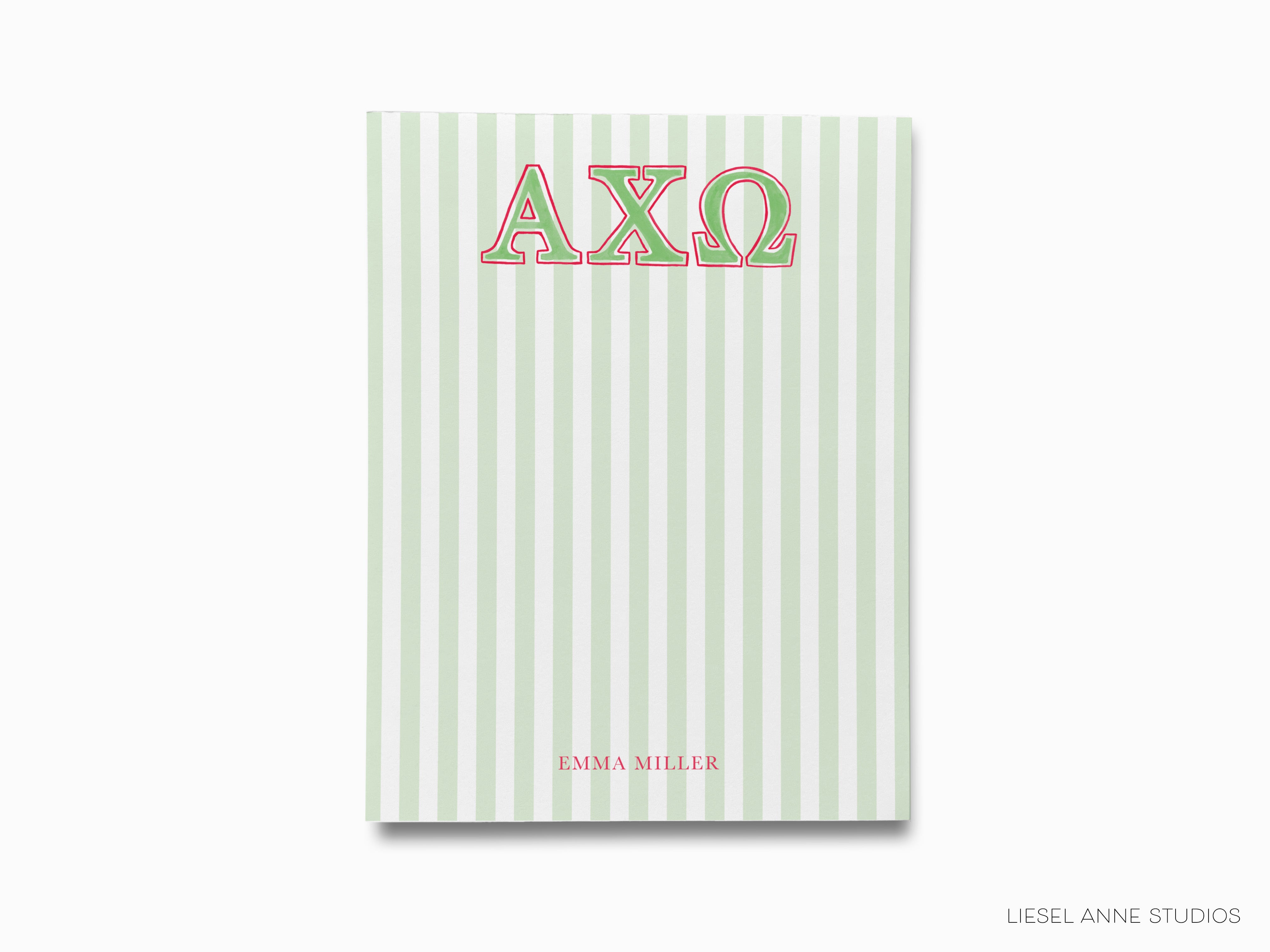 a green and white striped notebook with the word axq on it