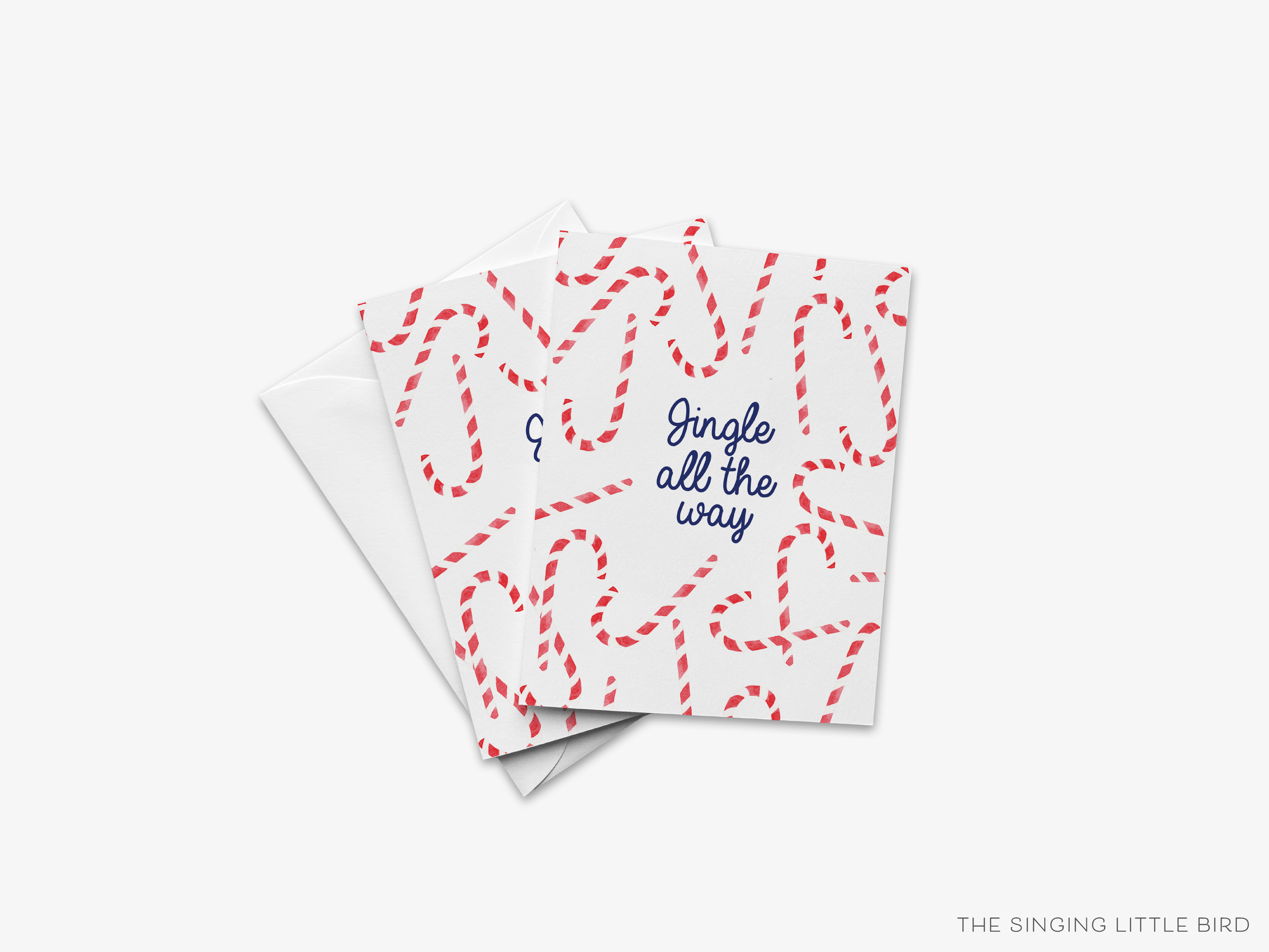 A white card with a pattern of red and white candy canes on it, along with the text "Jingle all the way" written in blue.