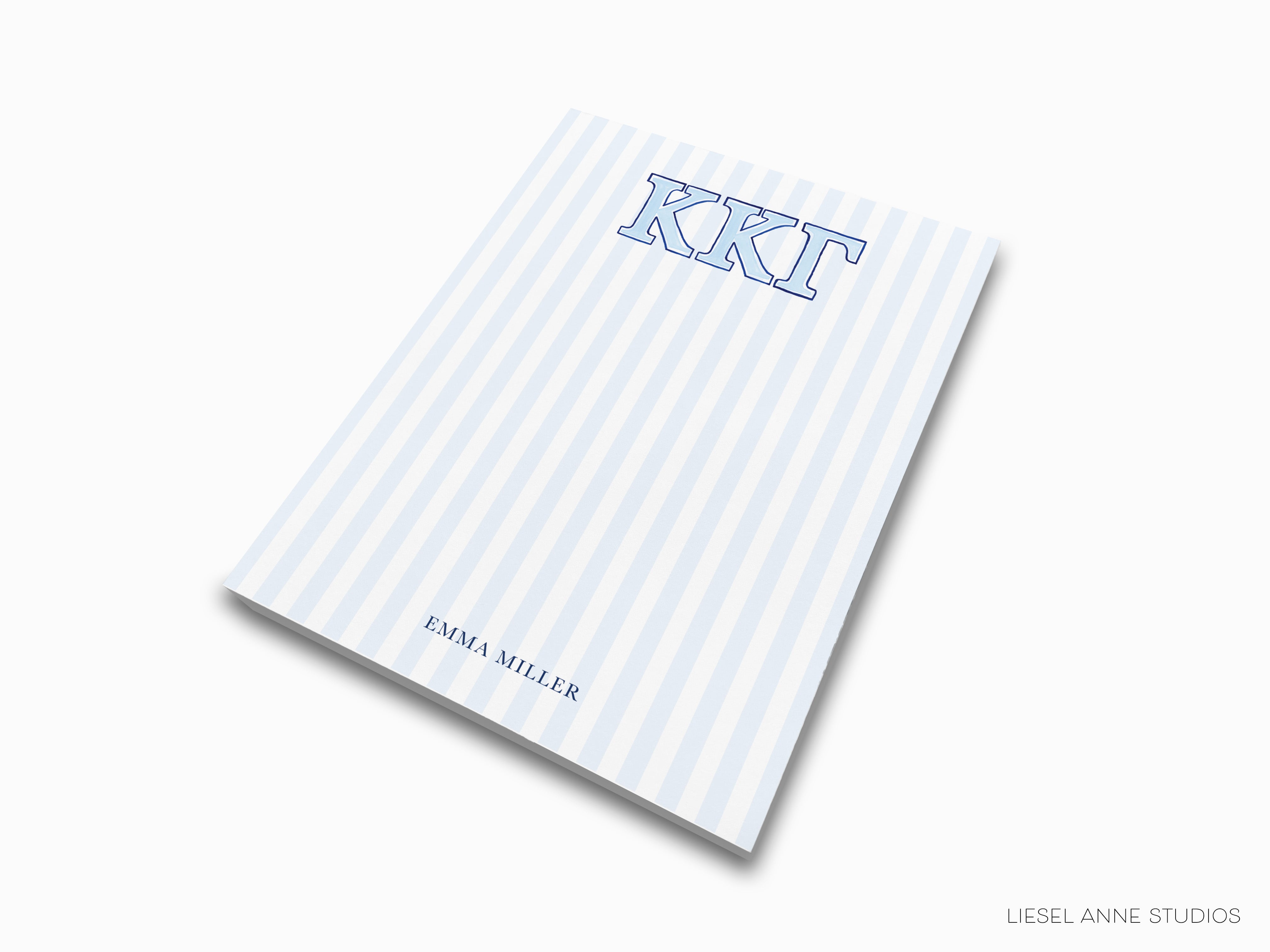 a blue and white striped notebook with the letter kkt on it