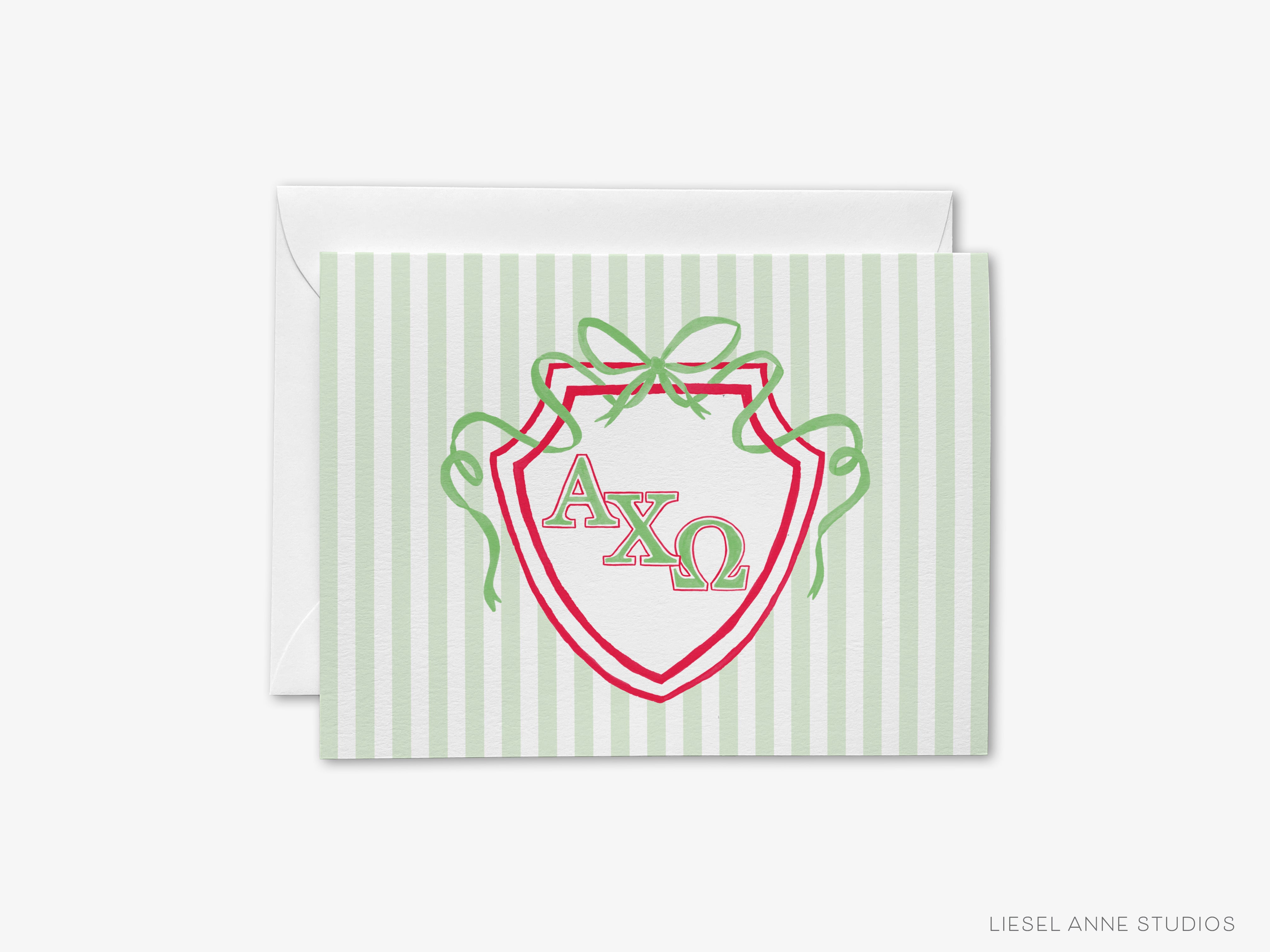 A greeting card with a shield-shaped design featuring the letters 'AXQ' in the center, surrounded by green ribbons.