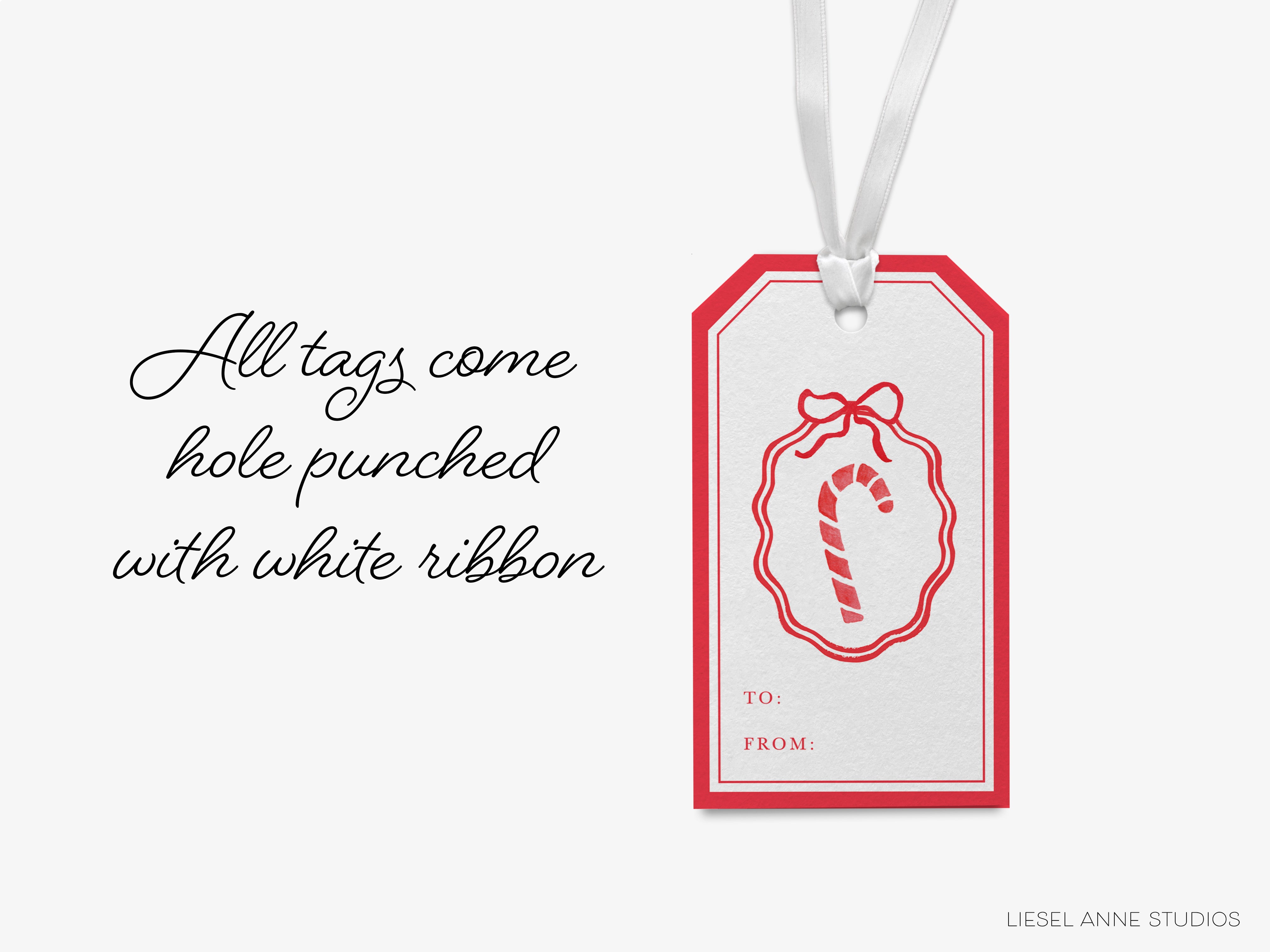 a white ribbon-trimmed tag with a red bow and a red candy cane design, hanging from a string.